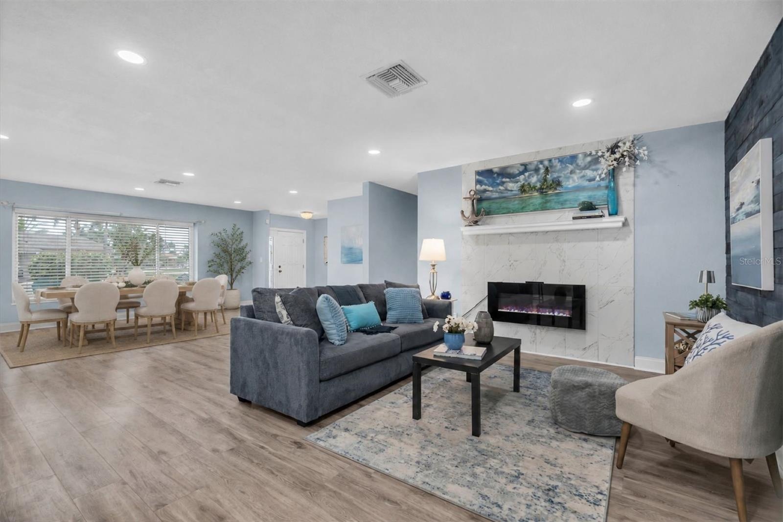 Open living and dining areas feature luxury vinyl plank flooring and a light coastal-inspired design.