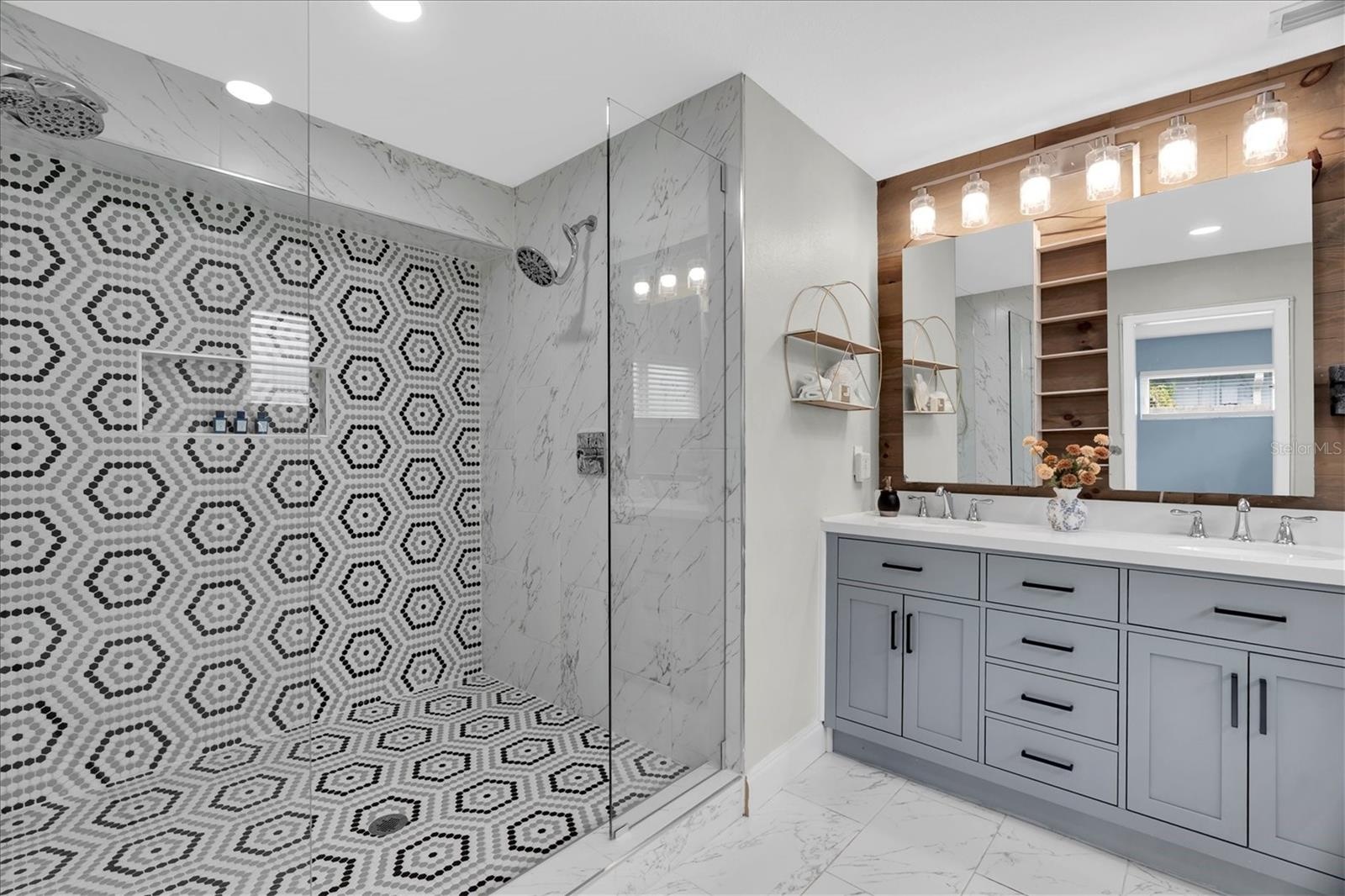 Spa-inspired primary bath features an oversized doorless walk-in shower with designer tile and dual shower heads.