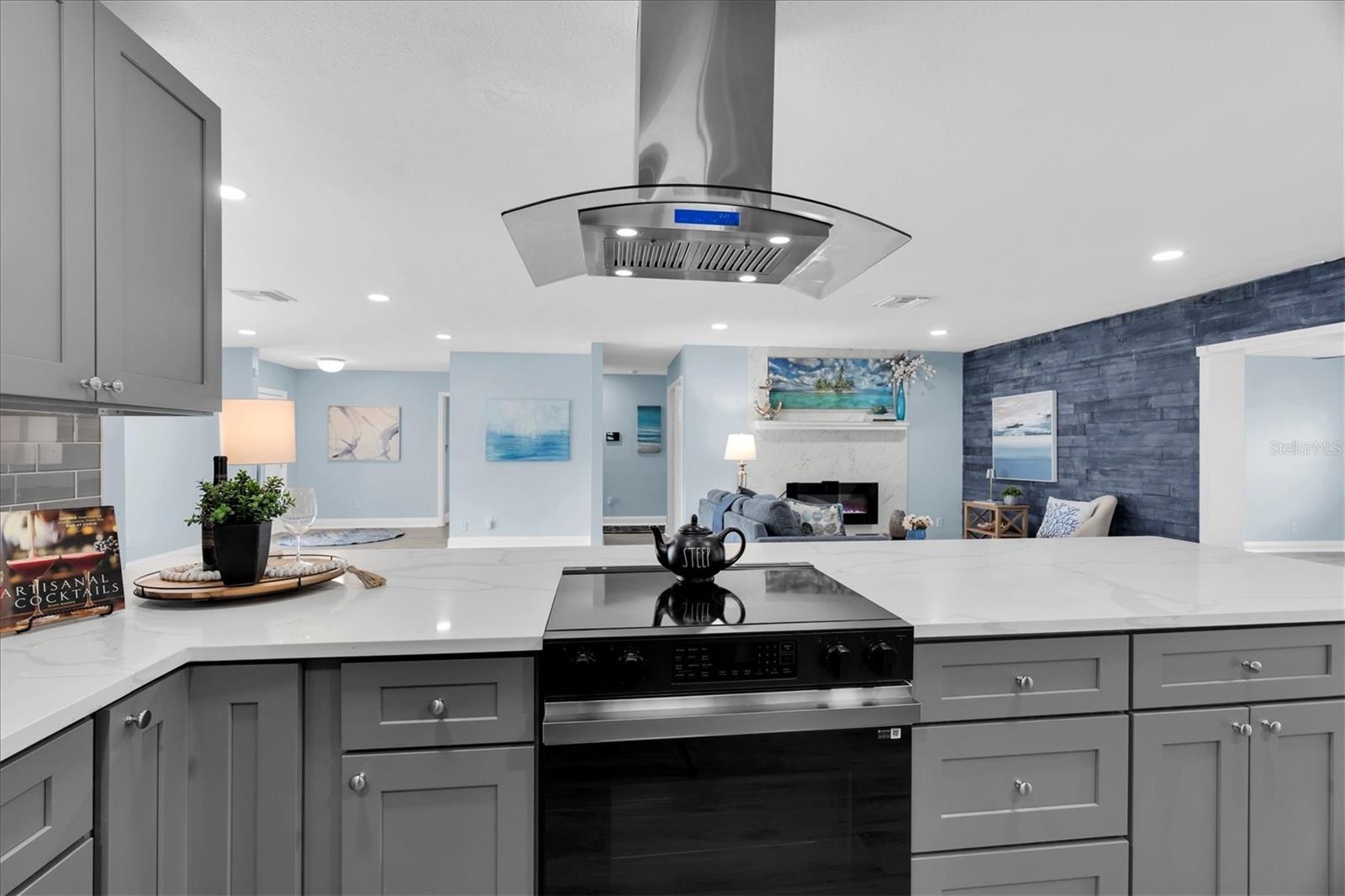 New stainless-steel appliances include a vented range hood and French-door refrigerator with an illuminated glass display panel.