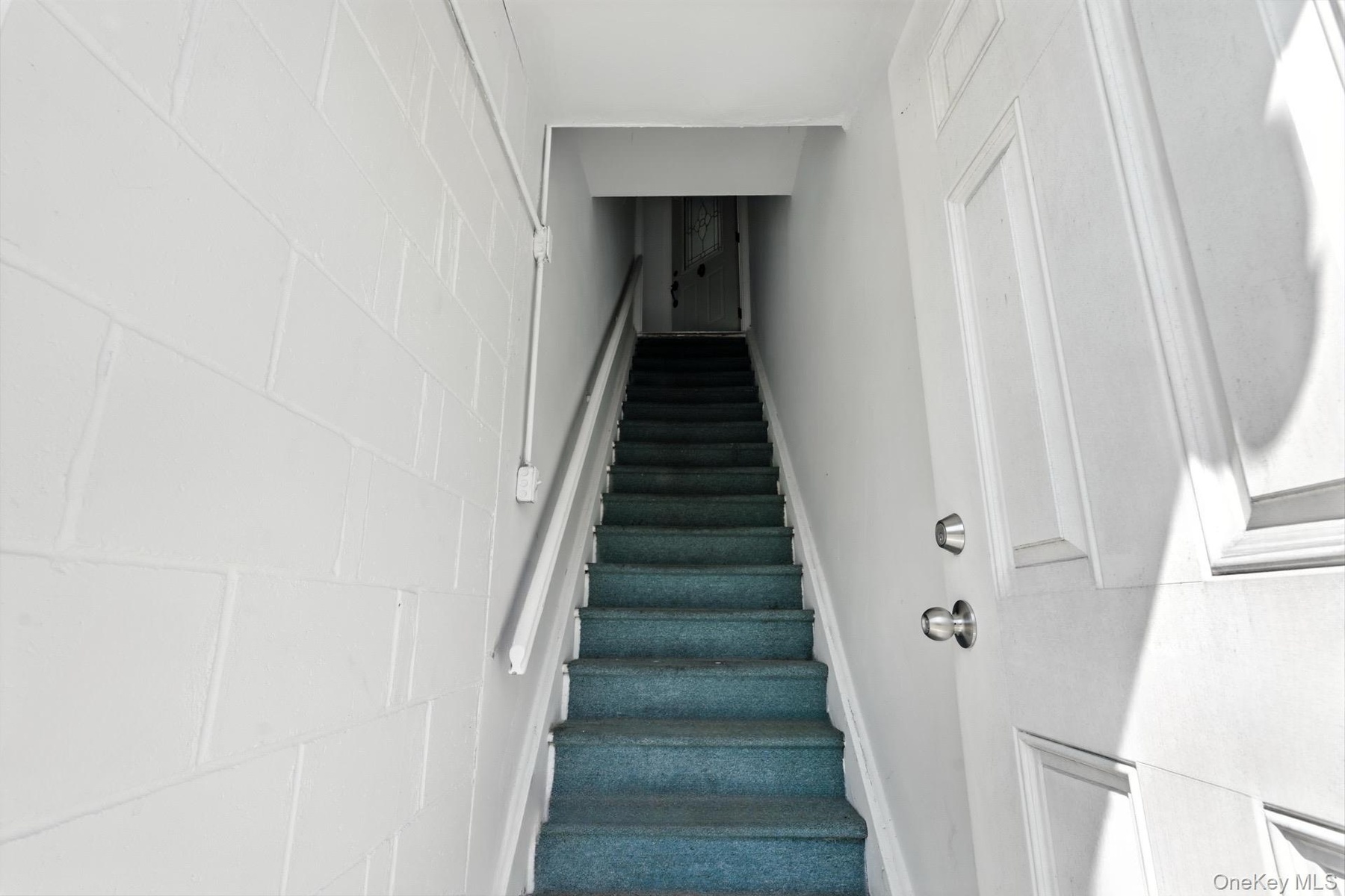 Stairway featuring concrete block wall