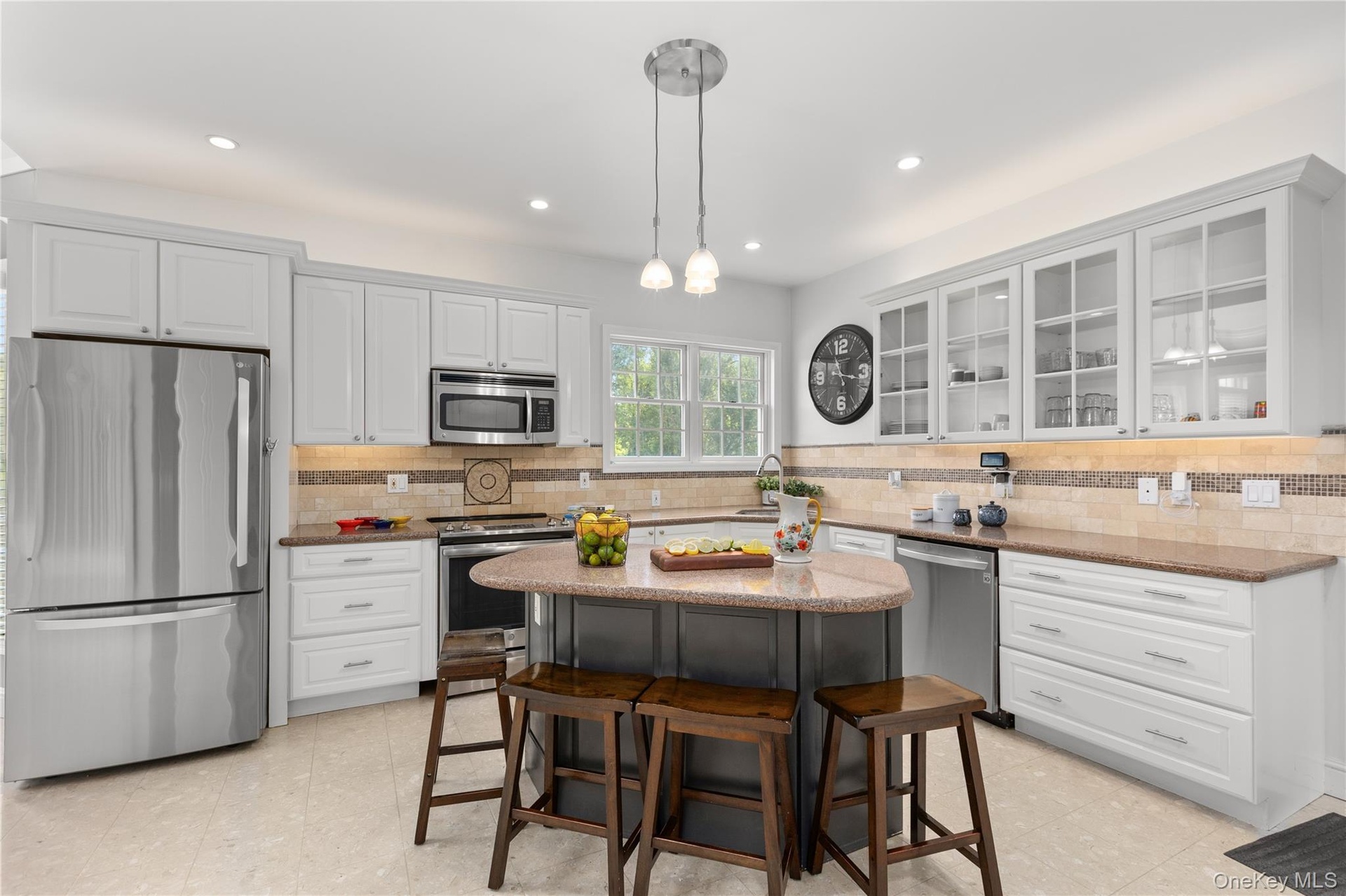 The kitchen is further enhanced by a uniquely contoured island with task lighting, and offers generous counter space and ample storage for effortless 