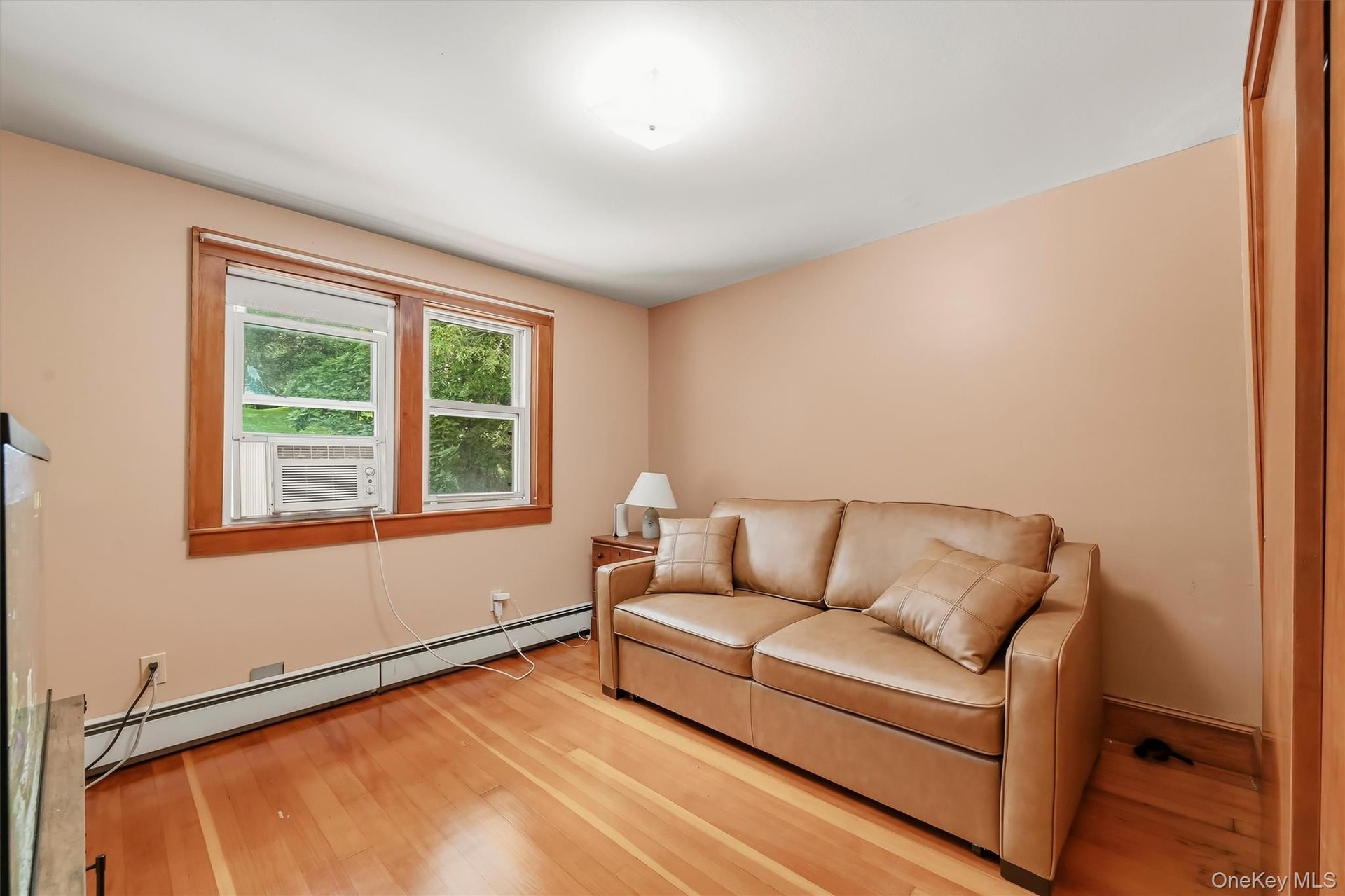Bedroom with hardwood floors, wood trim and ample natural light.