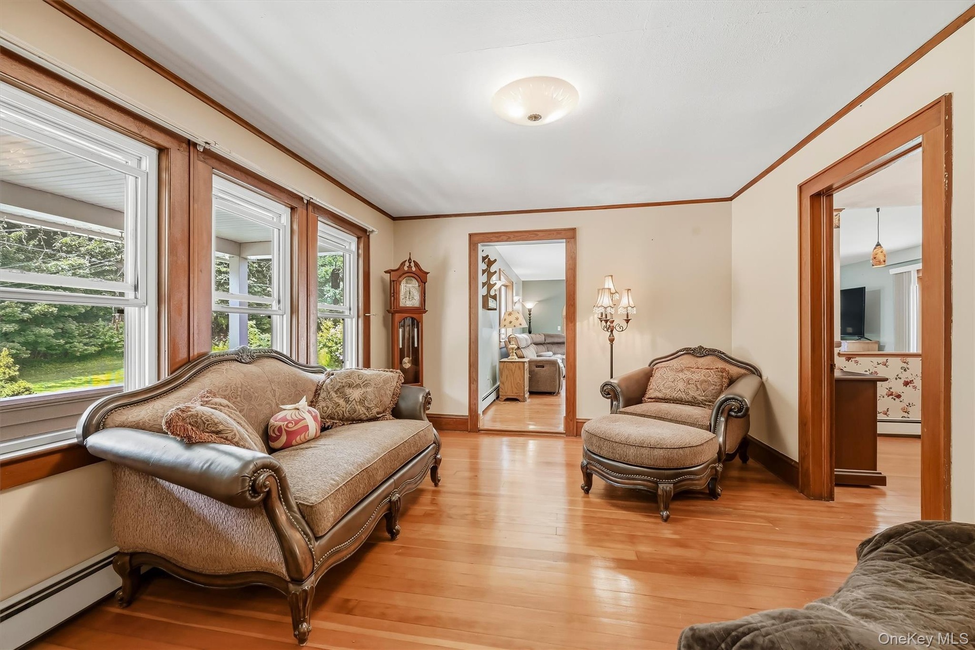 Living room with hardwood floors, natural wood trim, and large windows providing plenty of natural light.