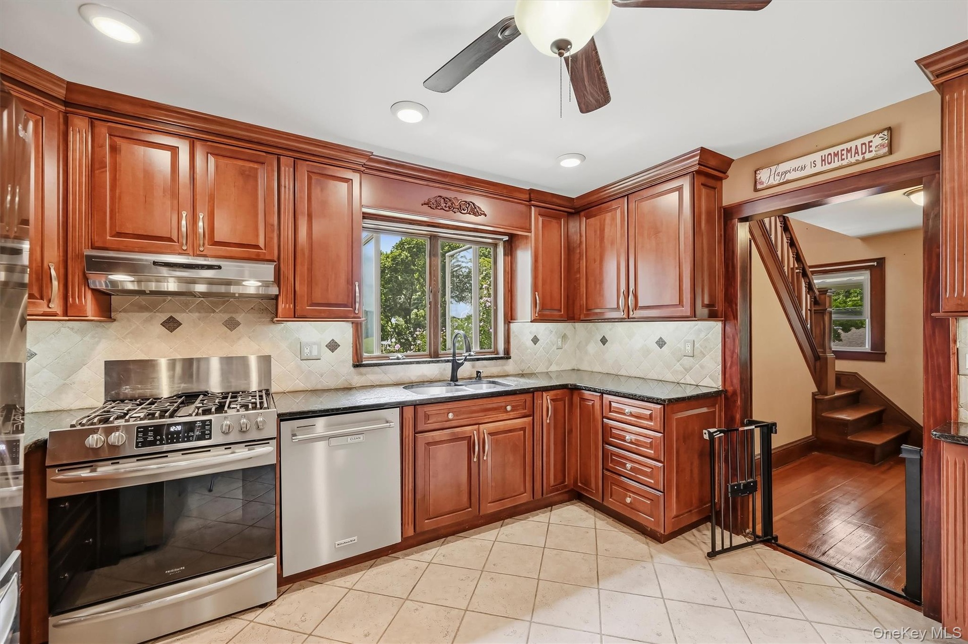 Kitchen with granite countertops, tile backsplash, stainless steel appliances and abundant wood cabinetry.