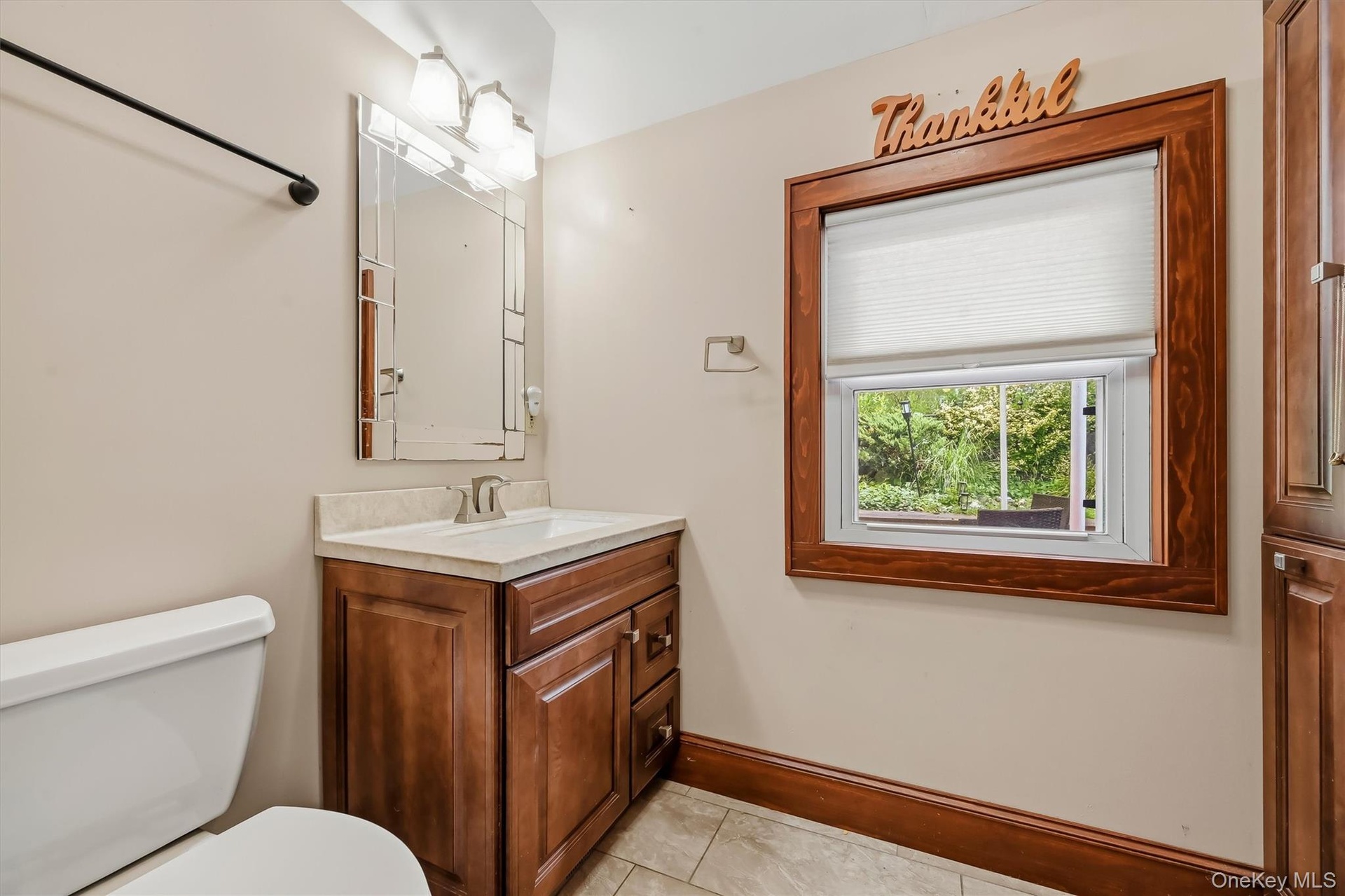 Full bathroom featuring a wood vanity, tiled flooring, and natural wood trim.