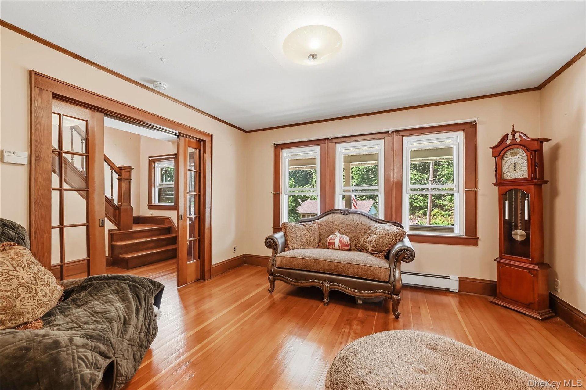 Living room featuring hardwood floors, wood trim, and French doors.