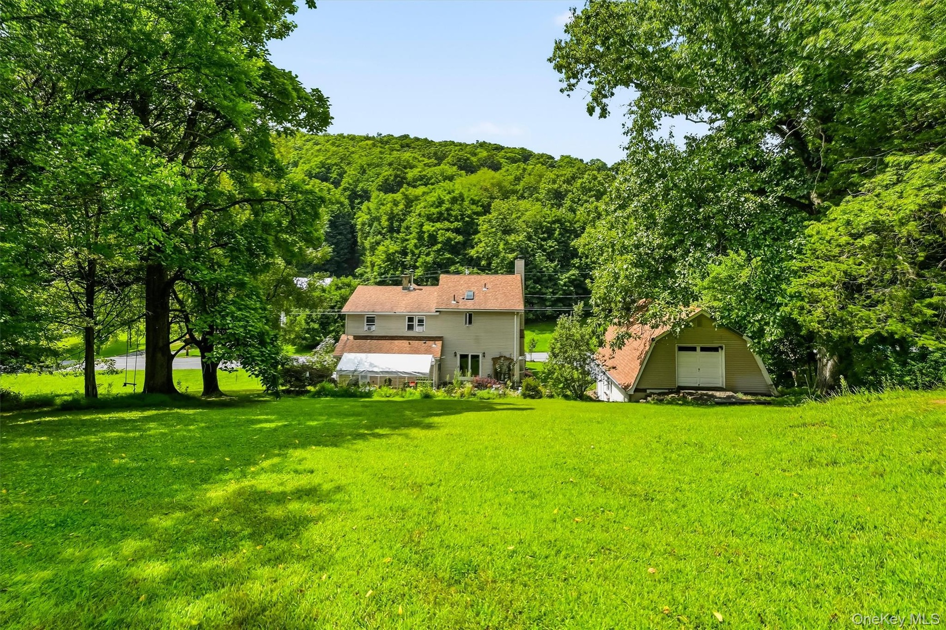 Expansive backyard with mature trees and detached garage.
