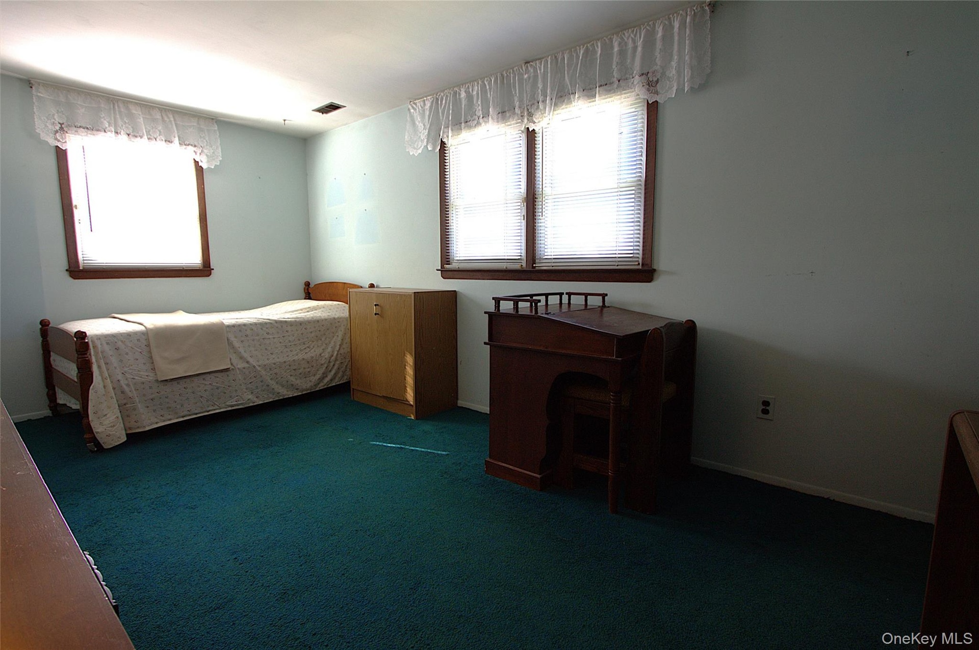 Wall-to-wall carpeting and multiple windows with wood trim
