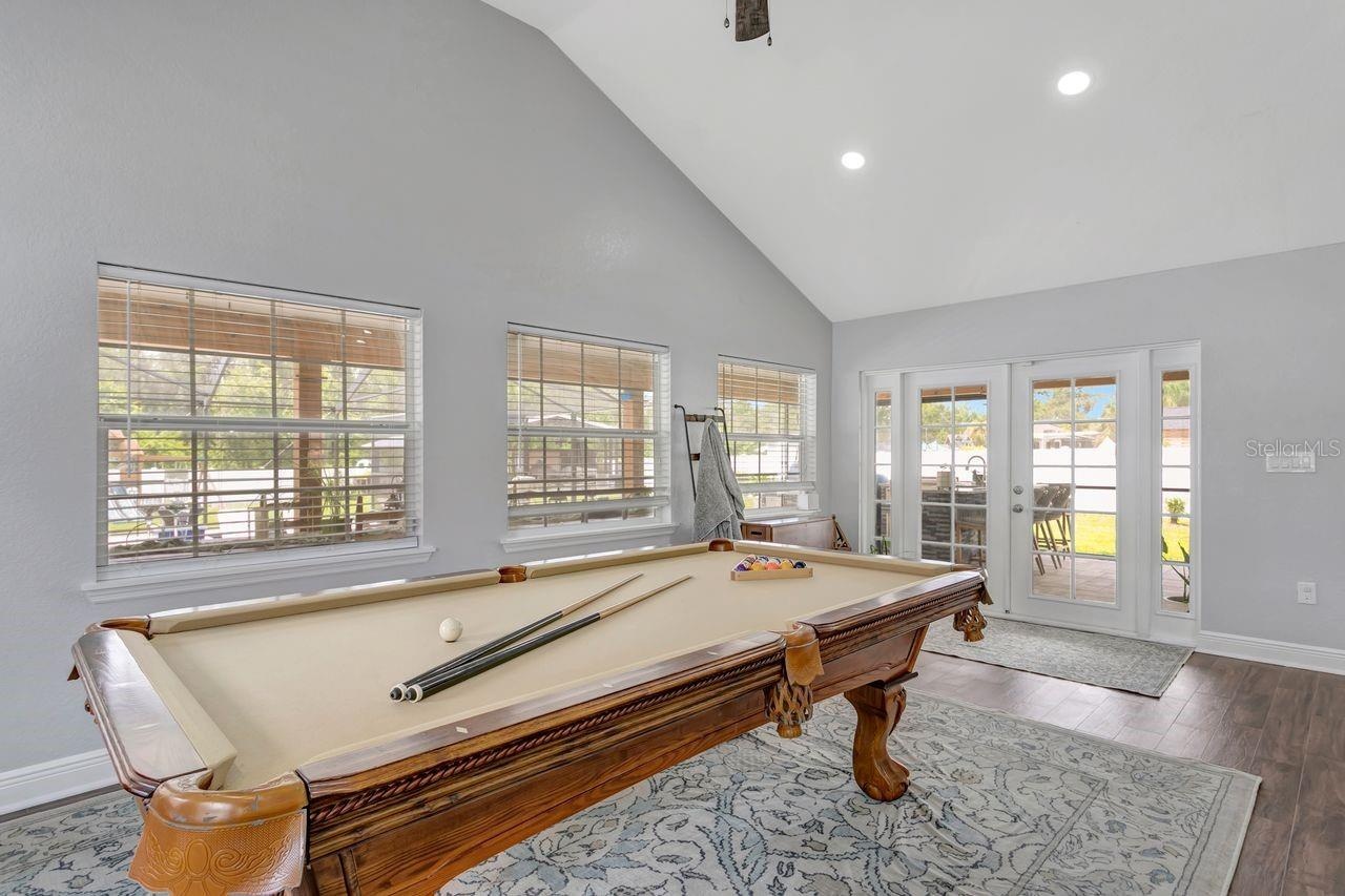 View of Great Room and French Doors to Extended Covered Lanai, Patio, Summer Kitchen, and Custom Pool