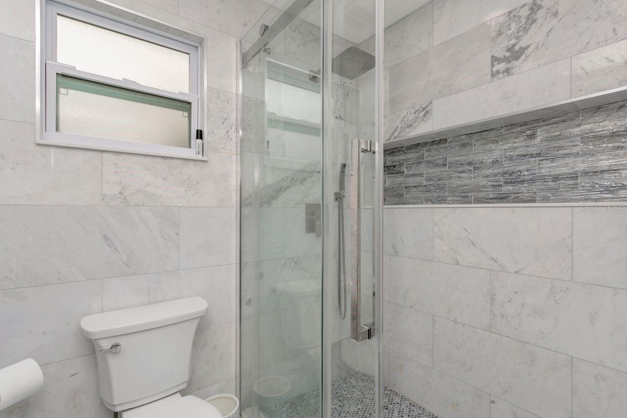 Remodeled Full "Pool Side" Bathroom with elevated fixtures, Shower with Tile to Ceiling and Recessed Decorative Niche; Located off the Kitchen