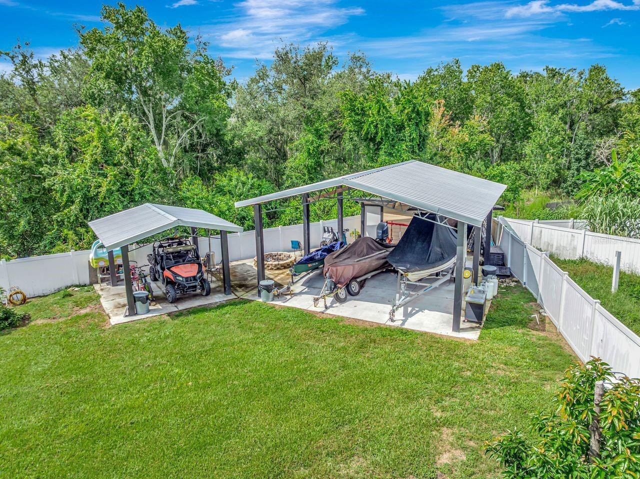Aerial View of Two Covered Open Air Storage Areas with Concrete Pads, Firepit, Shed and enough parking for all of your toys!