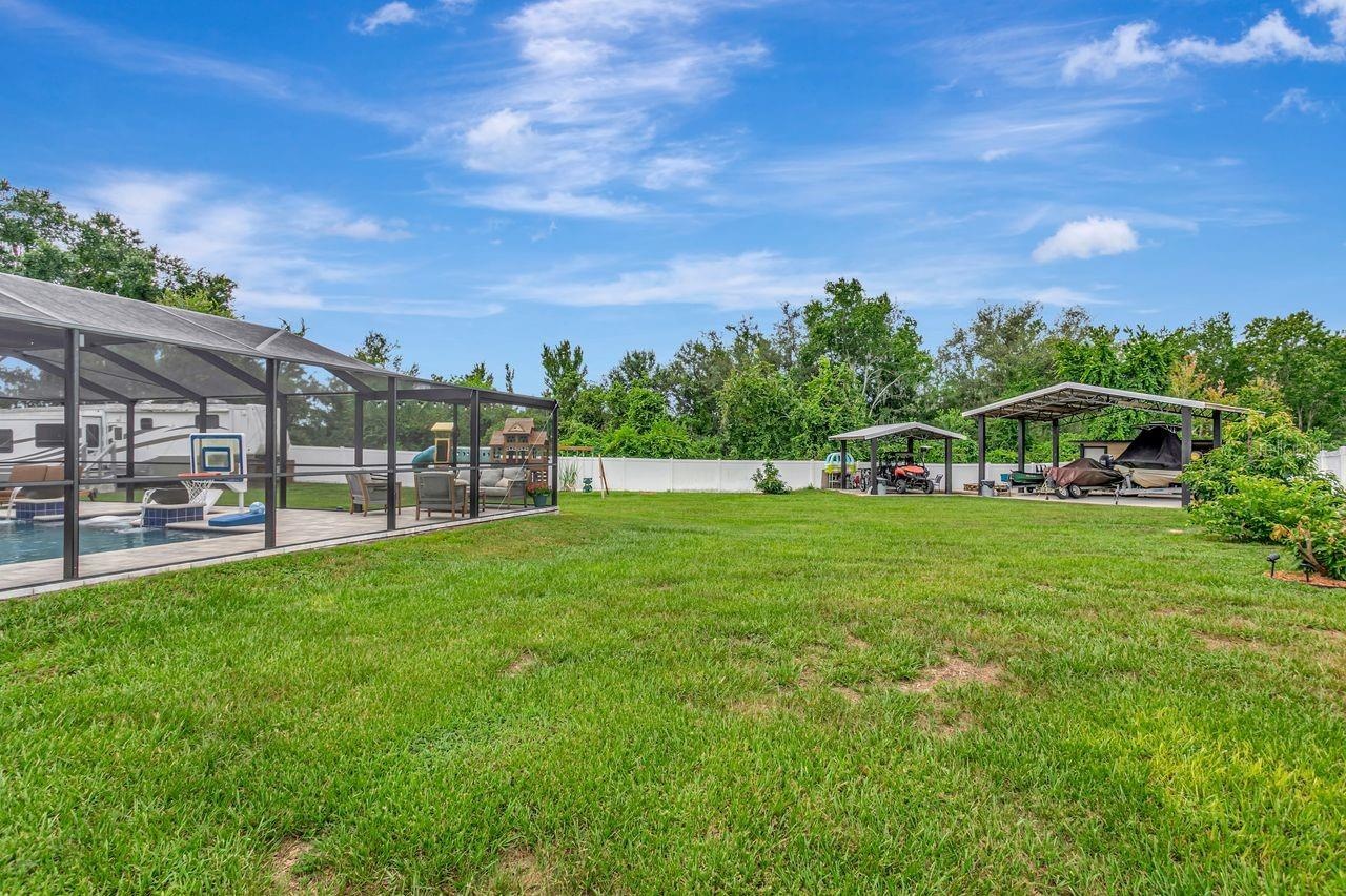 View of Backyard, Playground, Two Covered Open-Air Structured Storage areas with Concrete Pads, Firepit, and Shed. Bring the Boat- Bring the Toys - Th