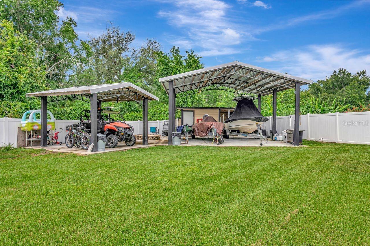 View of Backyard, Playground, Two Covered Open-Air Structured Storage areas with Concrete Pads, Firepit, and Shed. Bring the Boat- Bring the Toys - Th