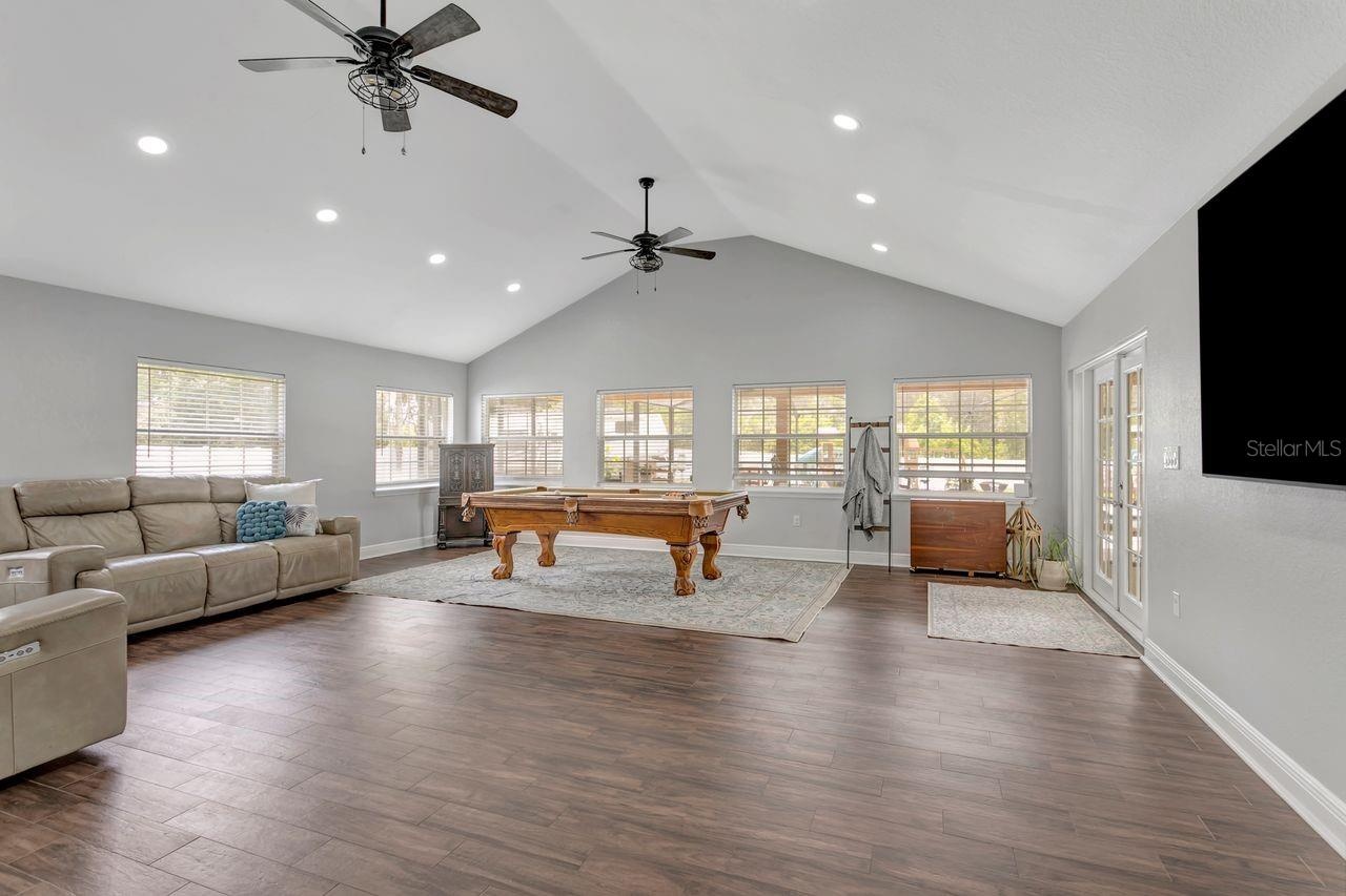 Great Room with Vaulted Ceilings, LVP Flooring, Dual Fans, Recessed Lighting; Tons of Windows, Natural Light, French Doors to your Patio & Covered Lan