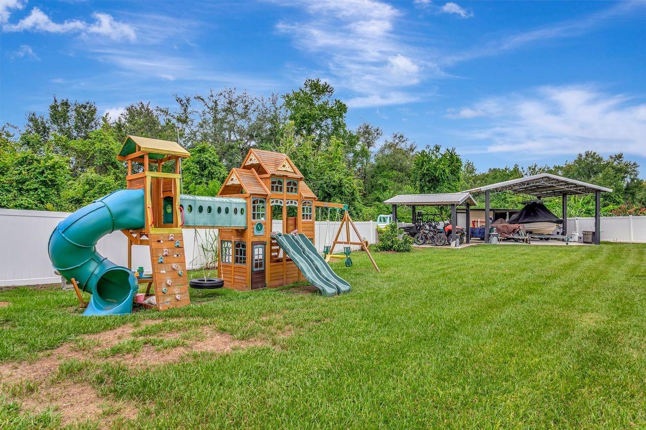 View of Backyard, Playground, Two Covered Open-Air Structured Storage areas with Concrete Pads, Firepit, and Shed. Bring the Boat- Bring the Toys - Th
