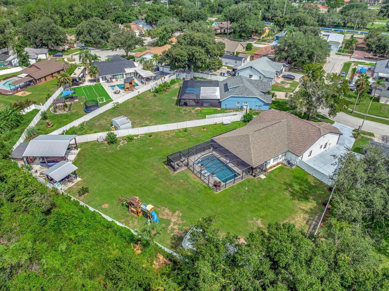 View of Backyard, Playground, Two Covered Open-Air Structured Storage areas with Concrete Pads, Firepit, and Shed. Bring the Boat- Bring the Toys - Th