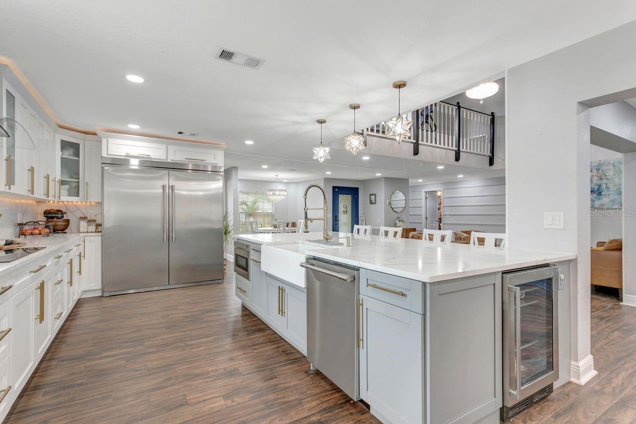 Remodeled Kitchen with upgraded custom cabinets with crown molding trim and lighting; elevated hardware and fixtures; quartz countertops; two-tone Cab