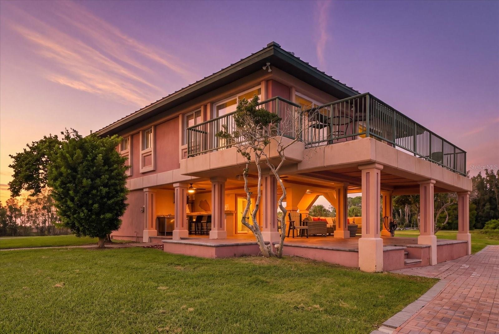 Twilight exterior highlighting the expansive covered outdoor living area.