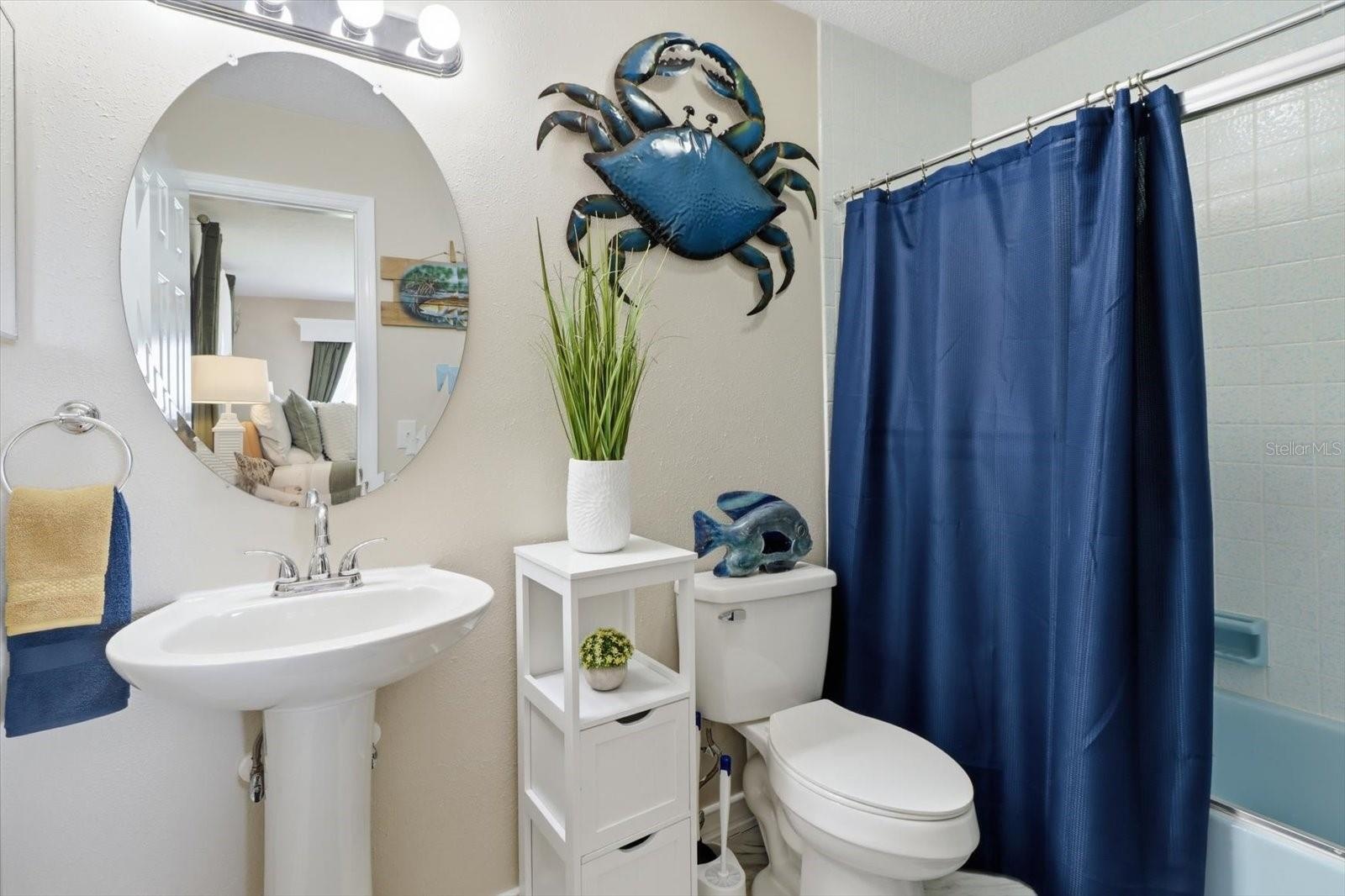 Guest bathroom with pedestal sink and tub/shower combination.