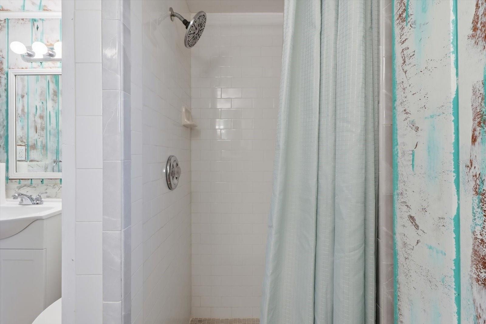 Walk-in shower detail with tiled surround.