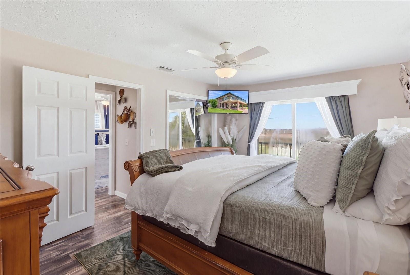Primary bedroom with large windows and waterfront exposure.