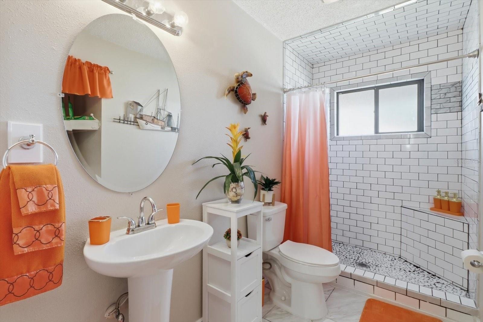 Updated bathroom featuring a tiled walk-in shower.