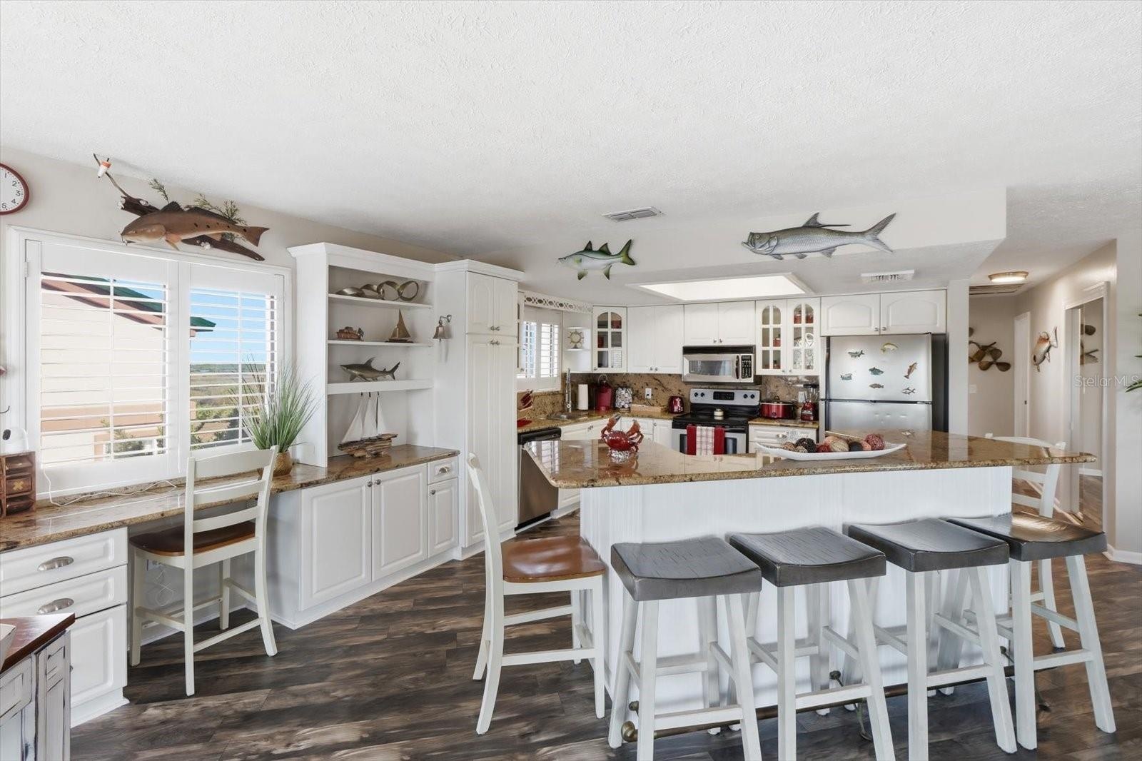 Kitchen and breakfast bar providing abundant seating and workspace.