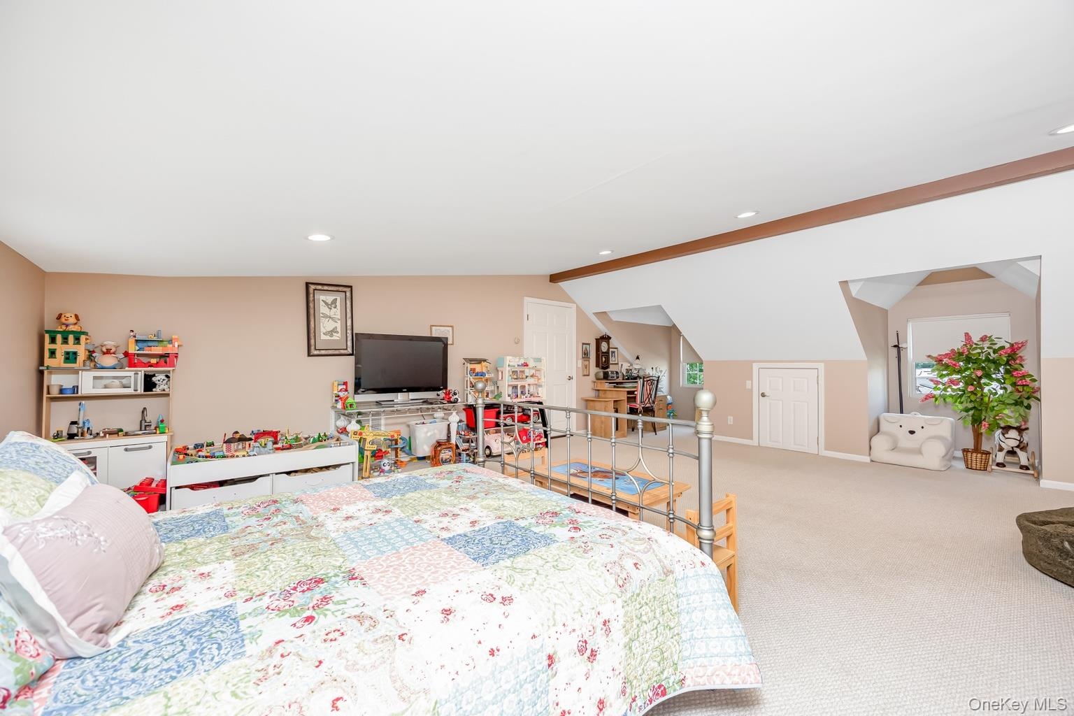 Spacious room featuring carpeting, recessed lighting, and sloped ceiling details