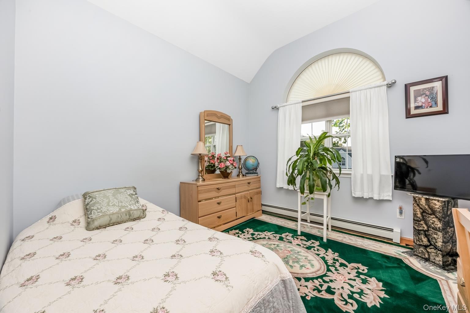 Arched window with sunburst shade and drapery rods