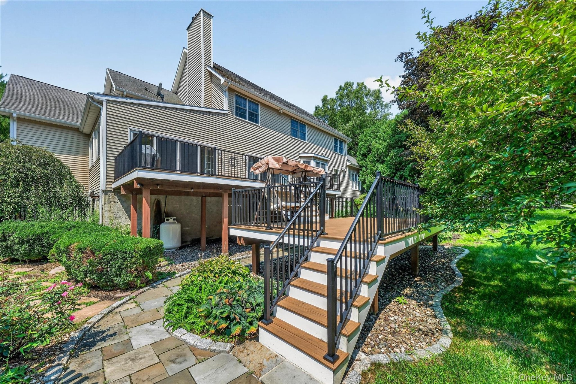 Stairs from the deck to a fenced-in pool area.