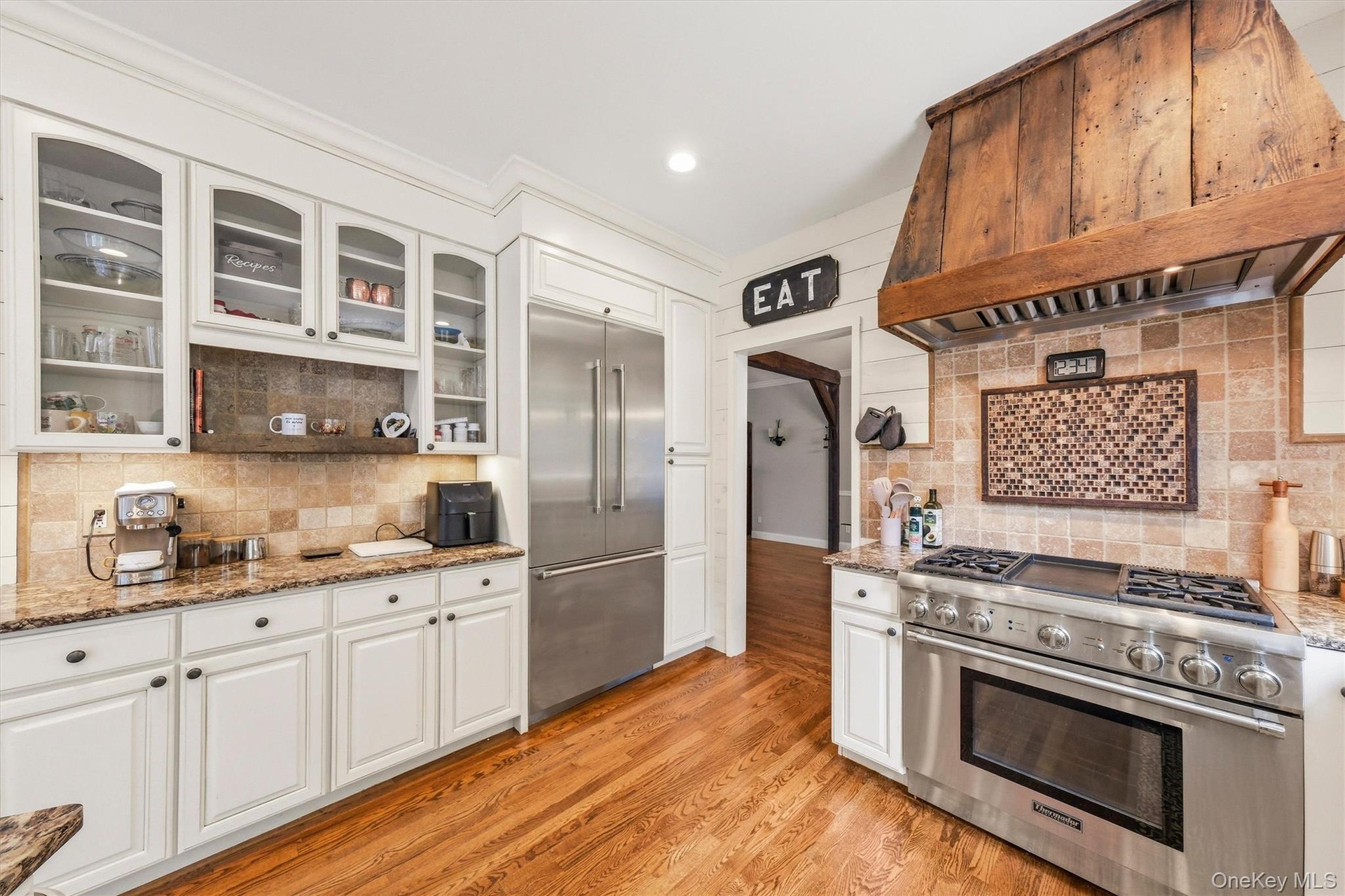 Enter an inviting eat-in gourmet kitchen, thoughtfully designed with abundant workspace, ample storage, and charming architectural details.