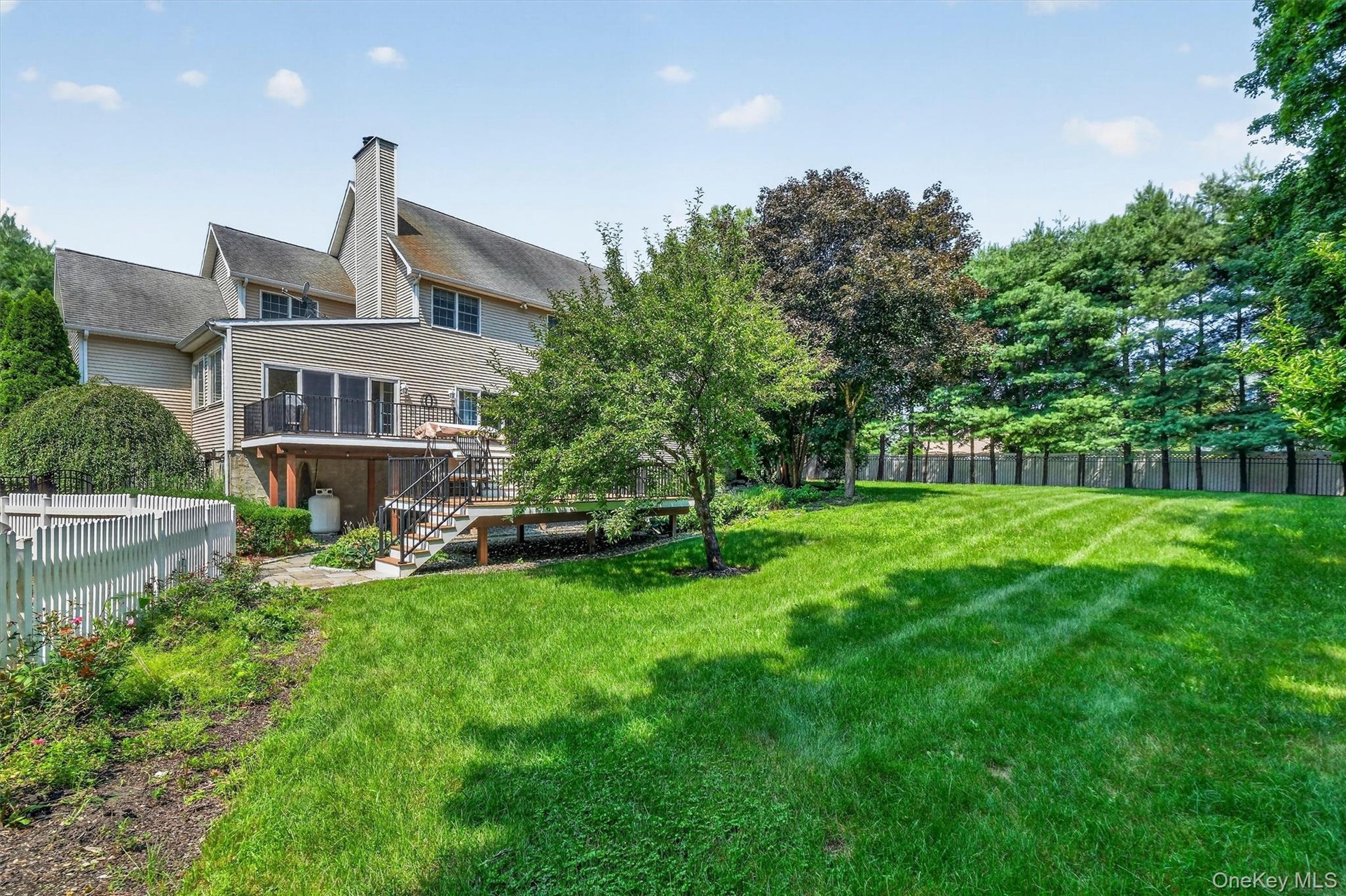 A beautifully manicured, fenced-in backyard completes this exceptional property.