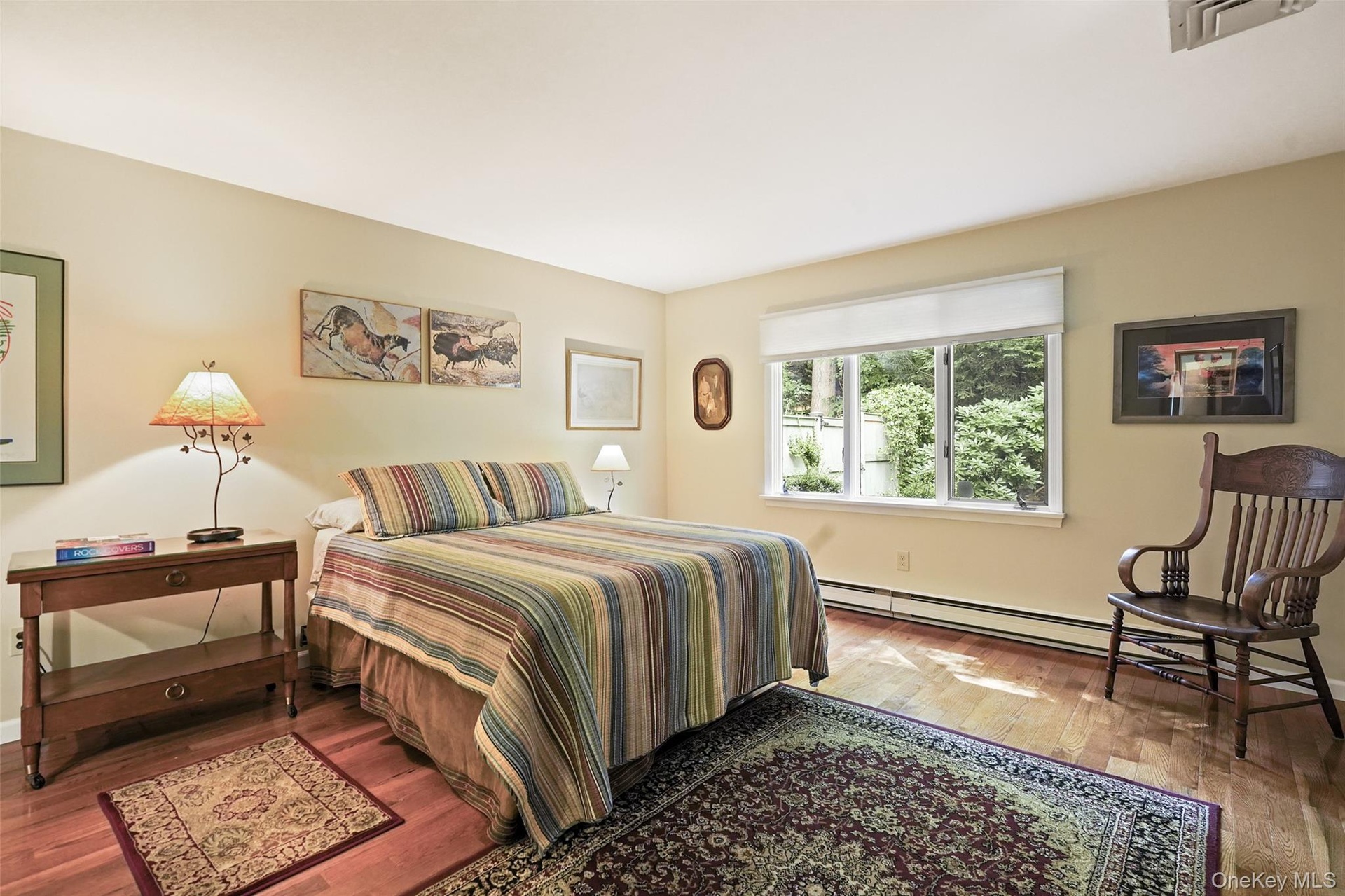 Spacious primary bedroom with window facing private backyard