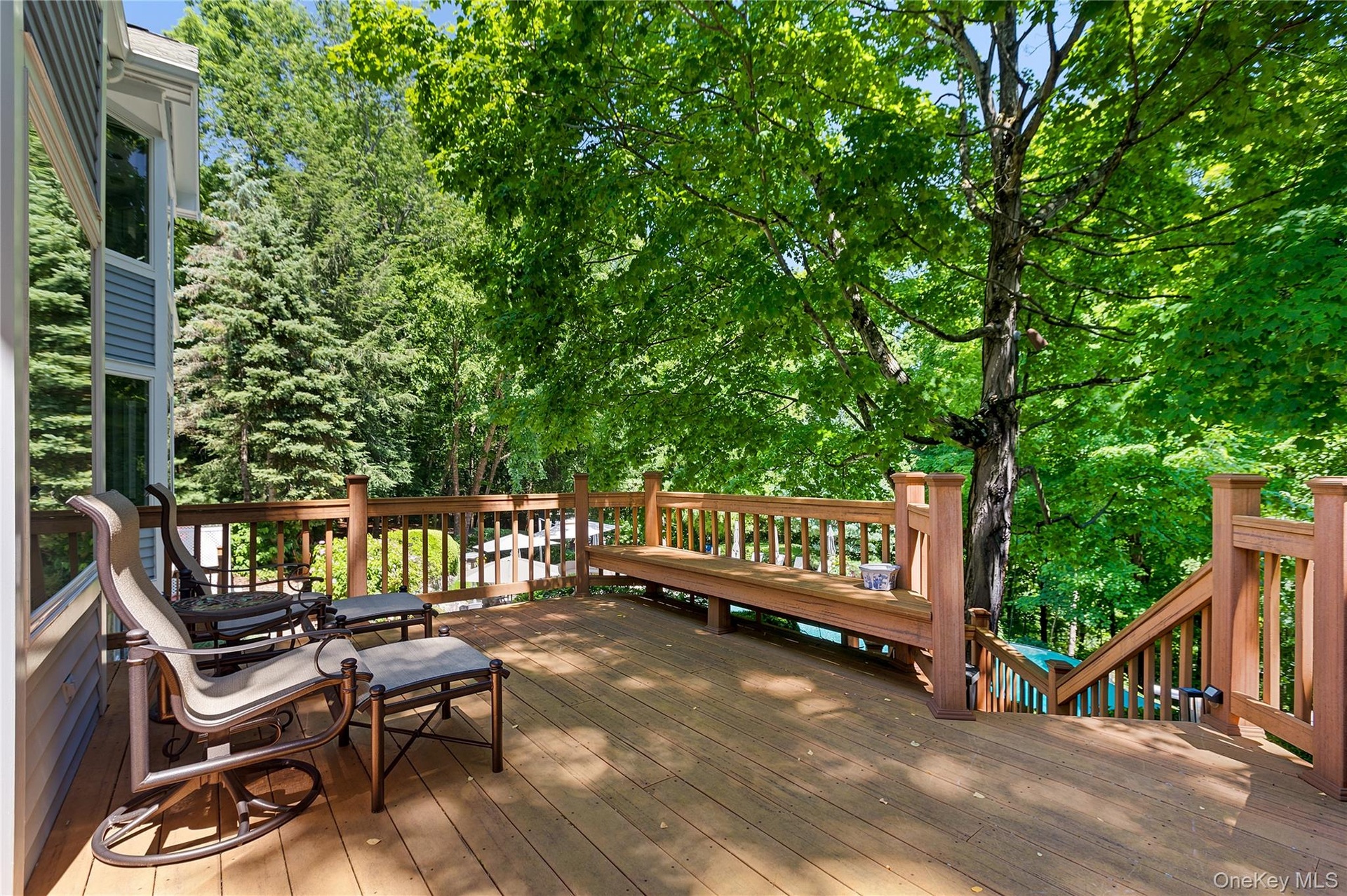 Area of deck with stairs down to hot tub, pool and patio.
