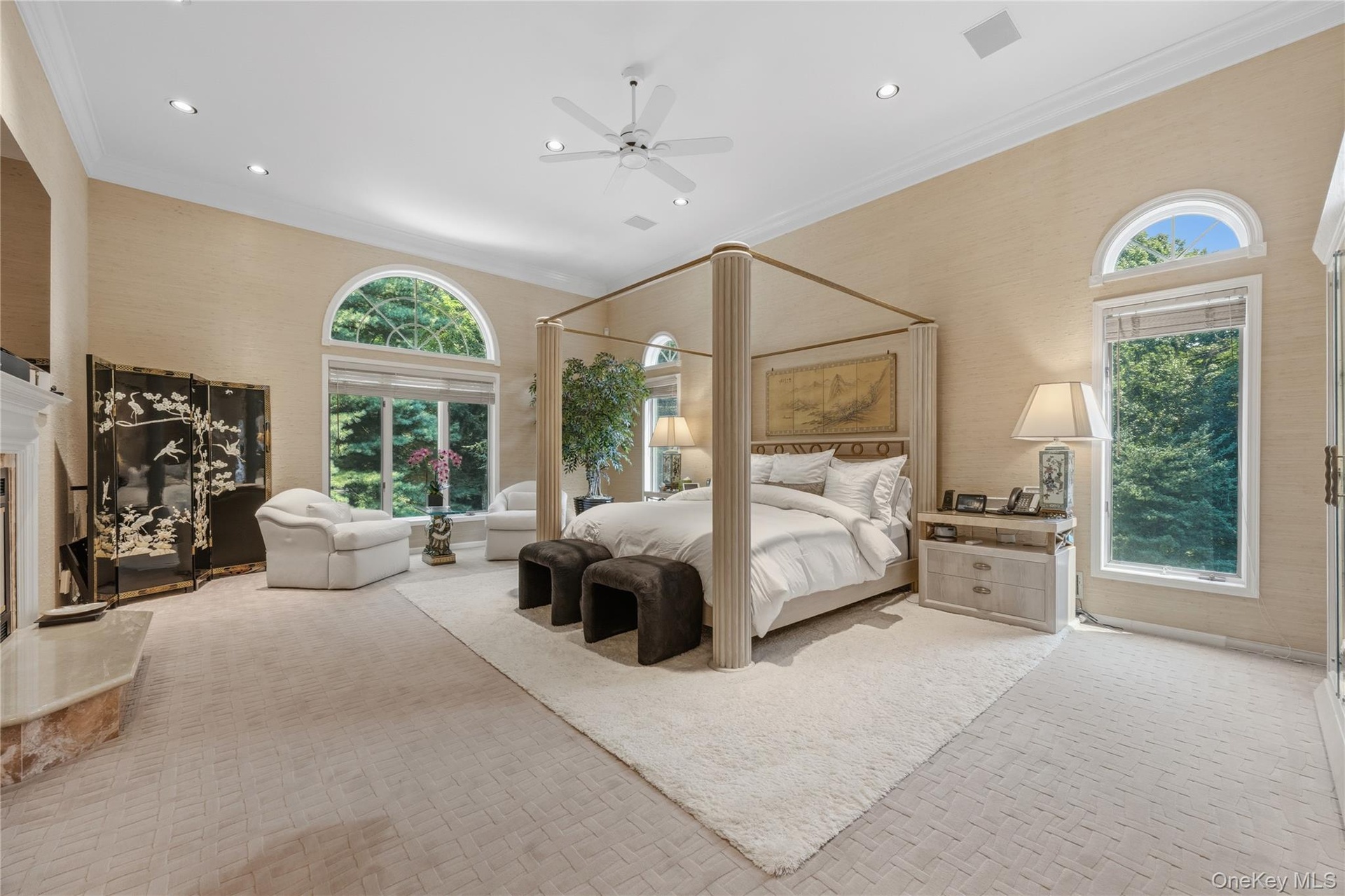 Breathtaking Primary Bedroom with arched entry, 3 large walk-in closets with track lighting with laundry chute, recessed lights, ceiling fan, B/I cabi
