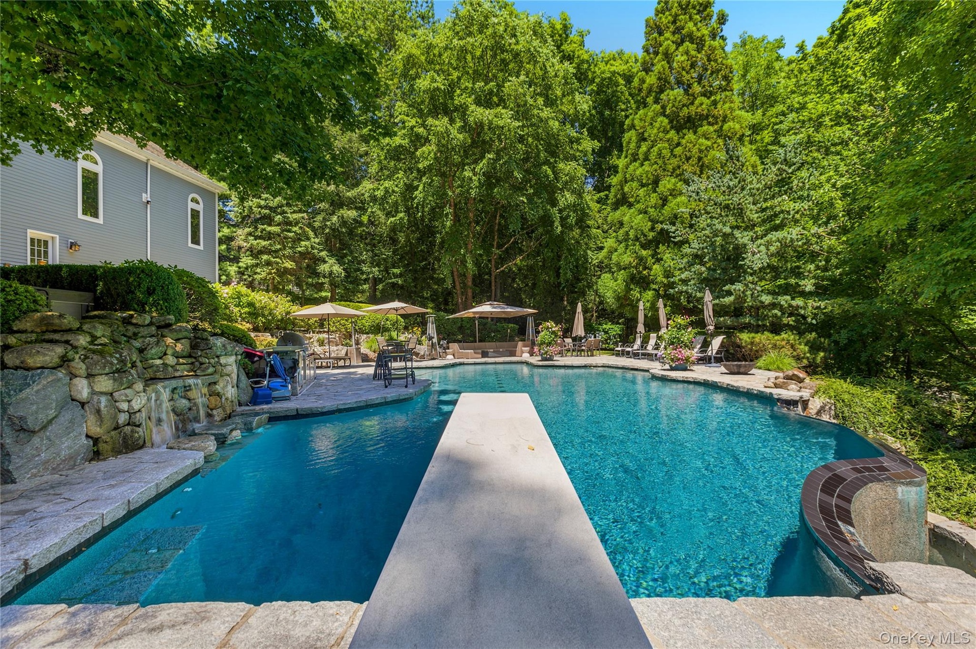 View from diving board of pool with infinity edge to the right