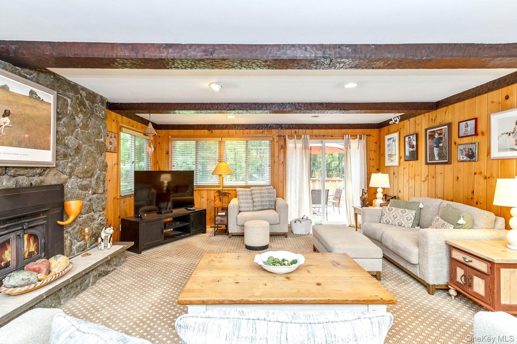 Rustic Farmhouse Den with Stone Fireplace and vaulted beam ceiling.