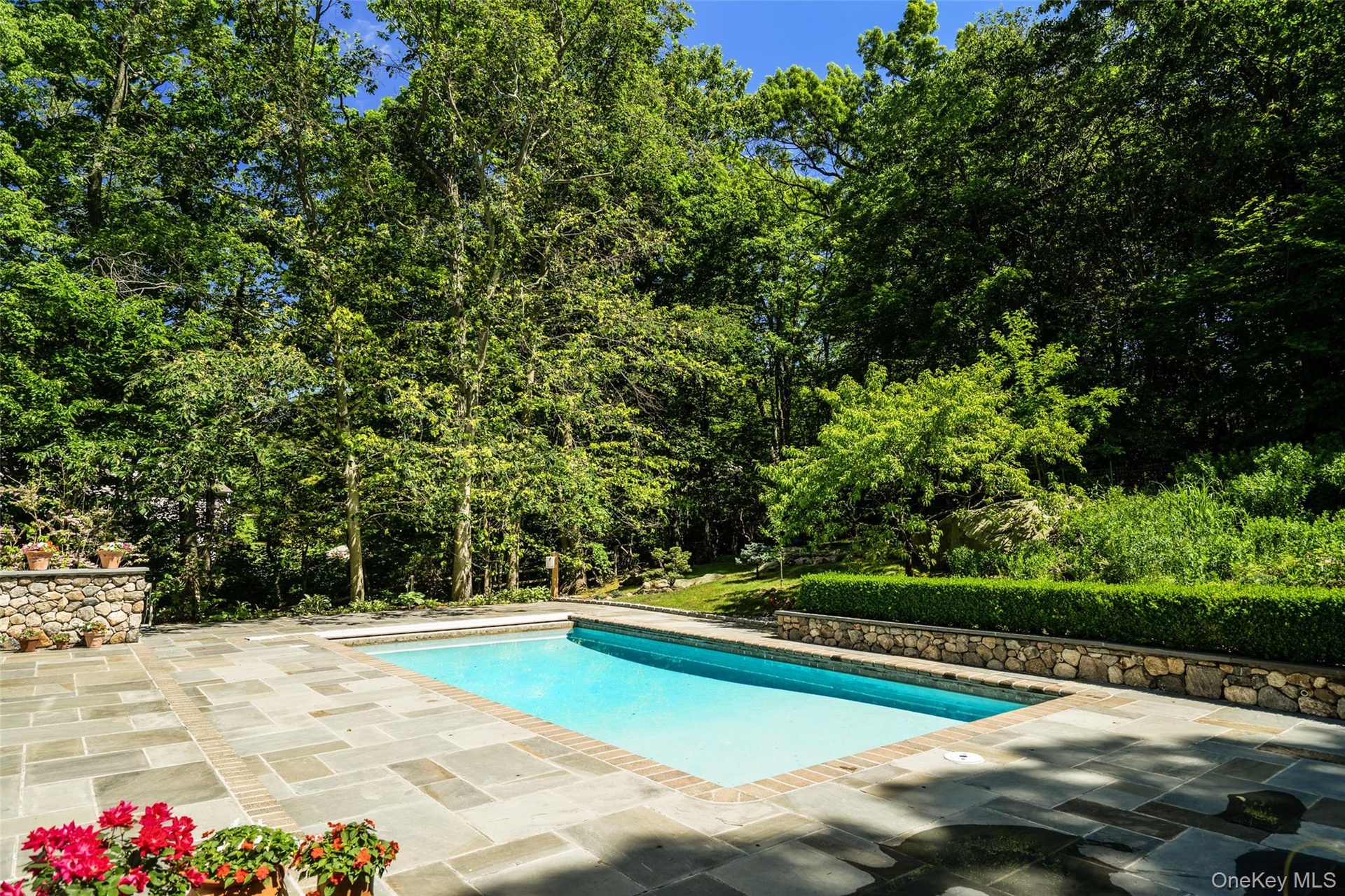 Note the gorgeous gardens behind the pool with grass areas to practice your favorite sports.