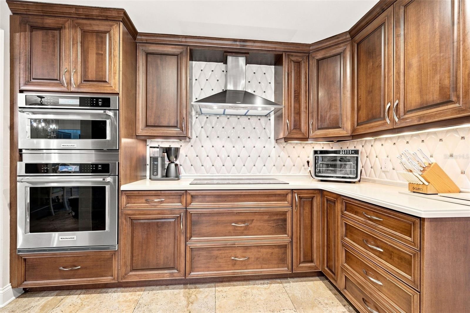 The beautifully appointed kitchen has high-end soft-close cabinetry and stainless appliances.
