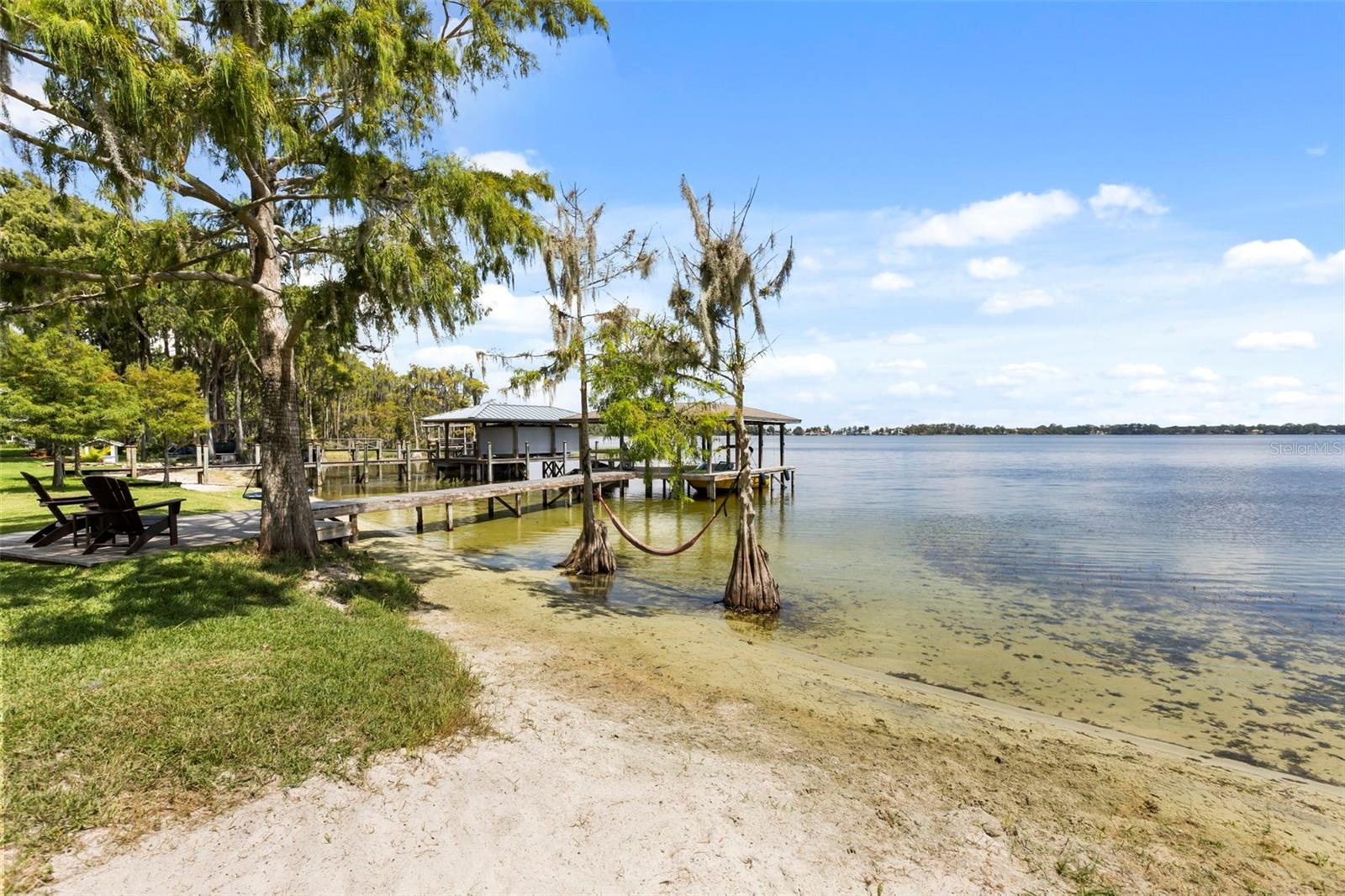 The sandy shoreline with gradual water entry is another exceptional feature, providing an inviting connection to the lake for swimming, paddleboarding