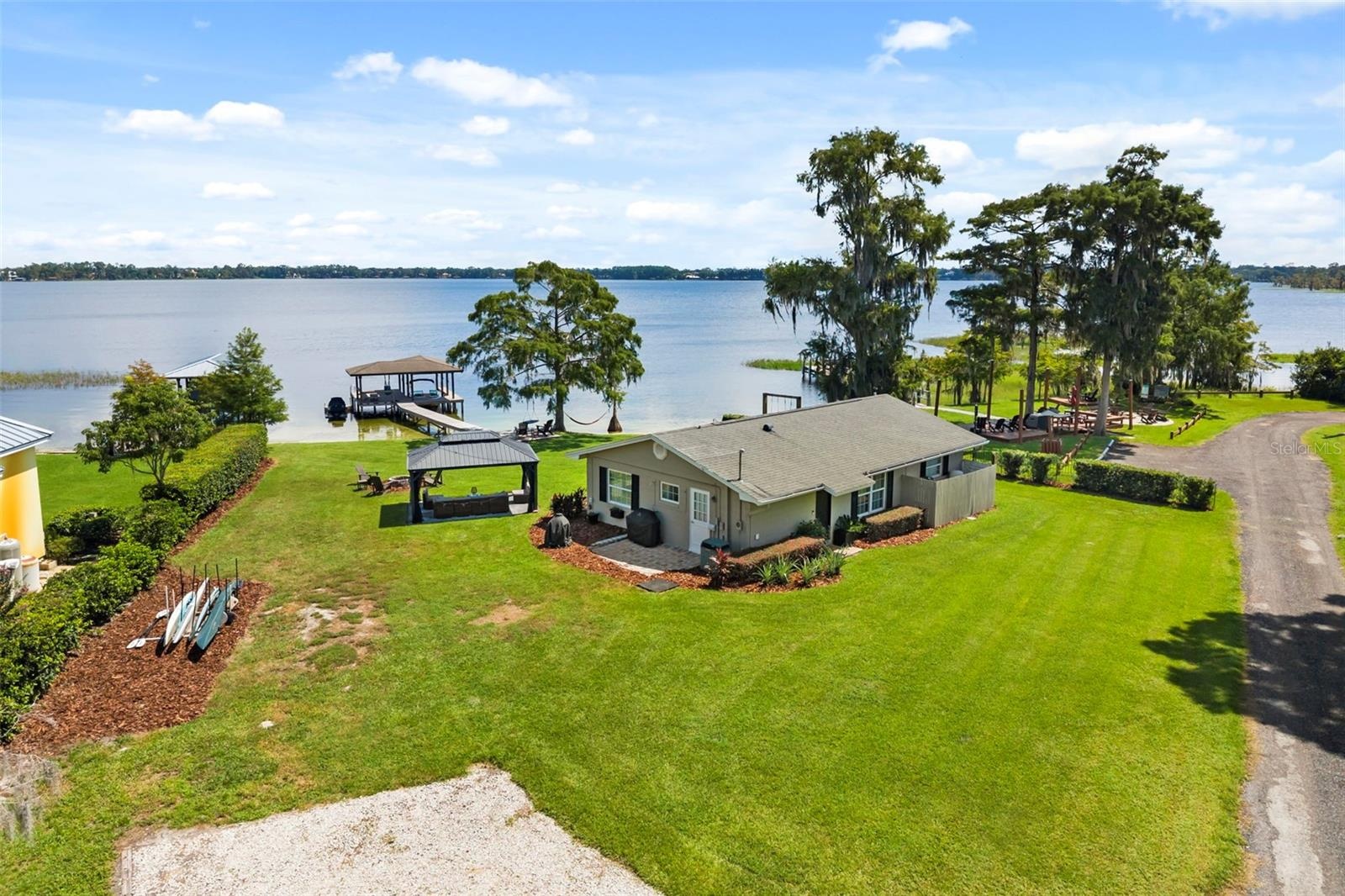 Lake Cottage Lane, featuring an oversized homesite, expansive Lake Sheen views, sandy shoreline, private dock and boatlift, and an existing 2BR/1.5BA 