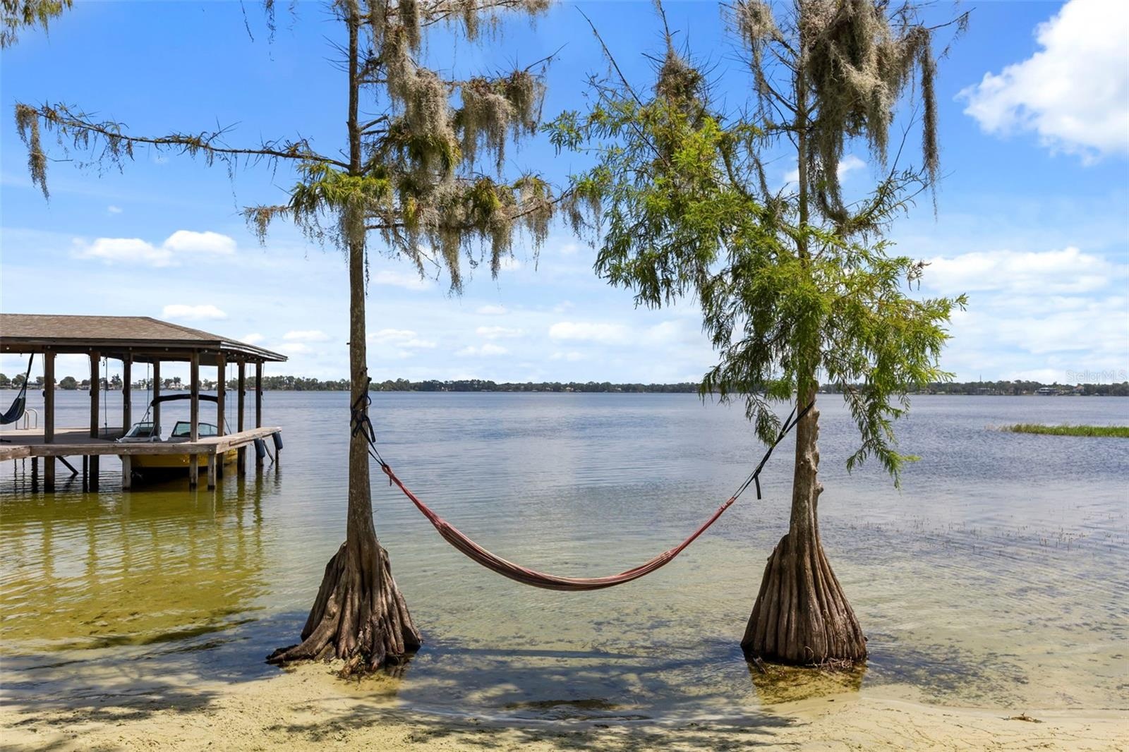 The sandy shoreline with gradual water entry is another exceptional feature, providing an inviting connection to the lake for swimming, paddleboarding