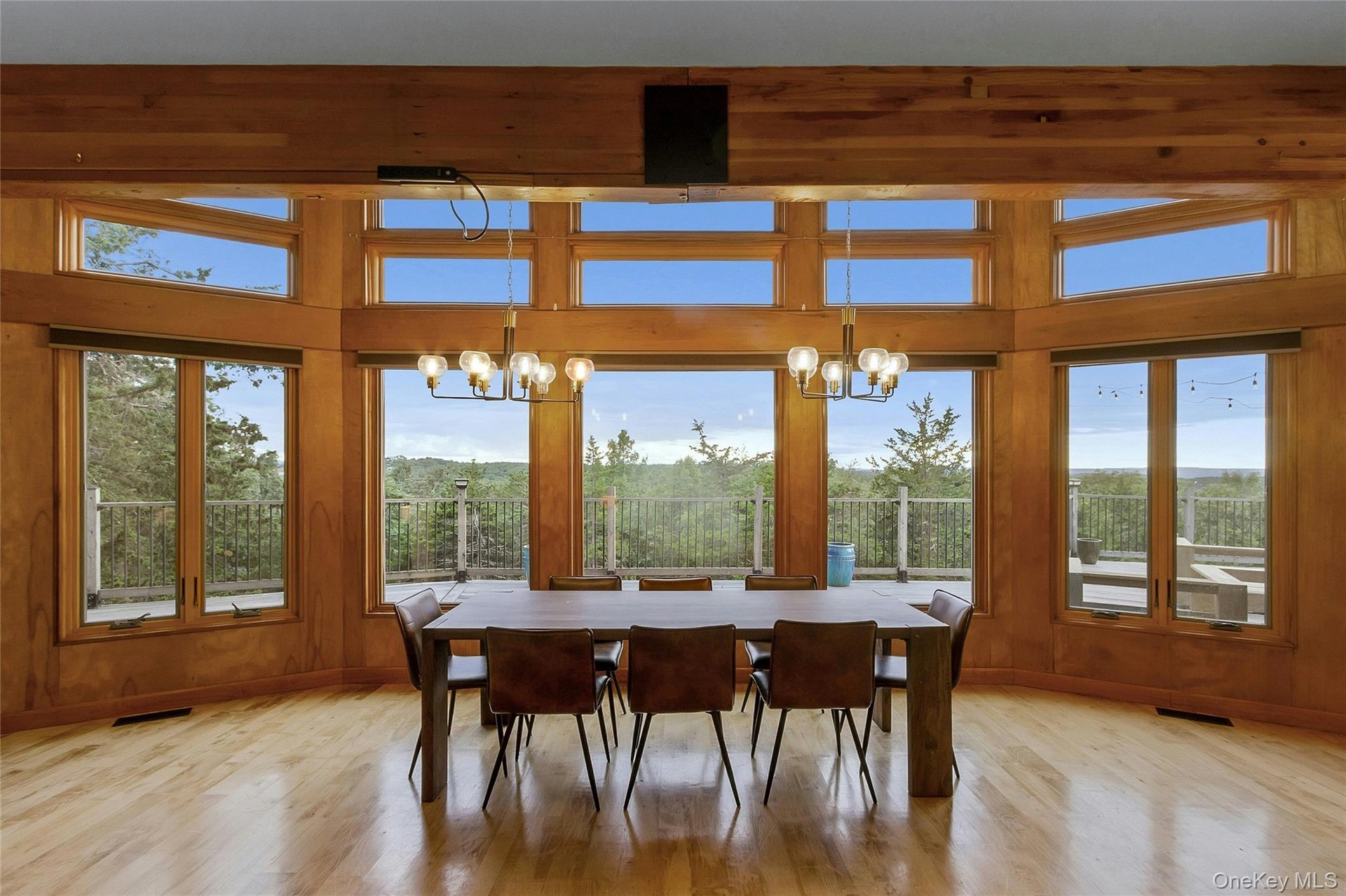 Hardwood flooring, wood-paneled walls, exposed wood beams, and a chandelier lighting fixture