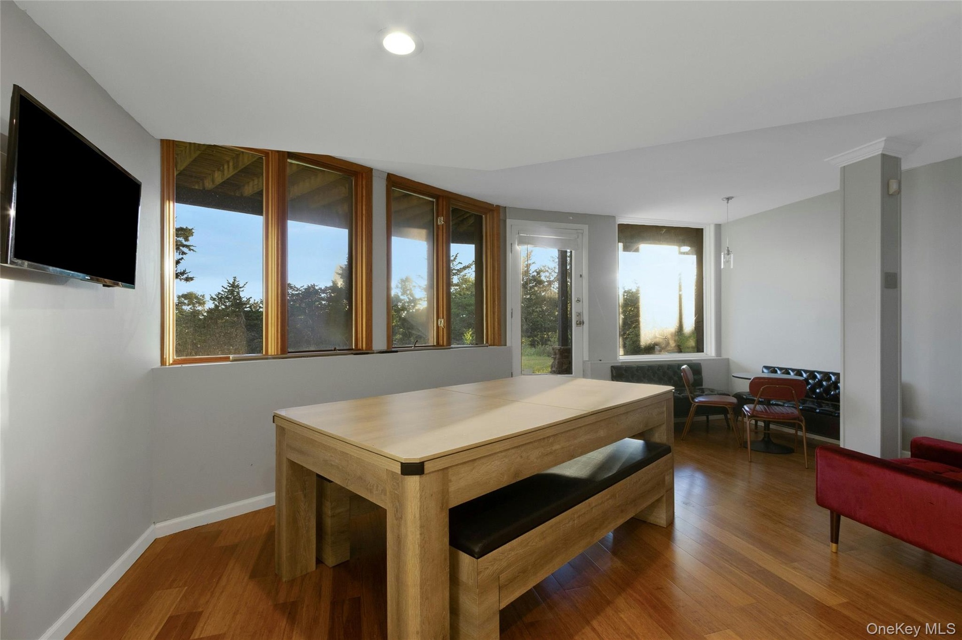 Wood-finish flooring throughout, complemented by a recessed light and multiple windows