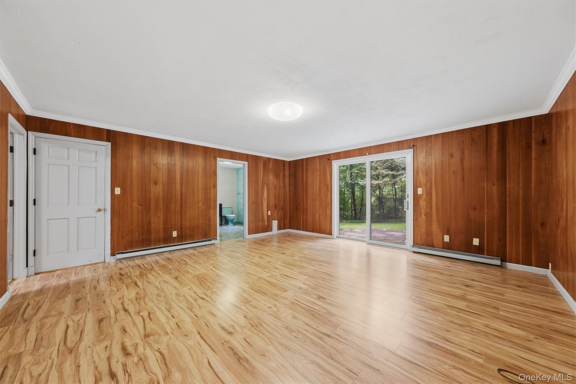 Enormous family room with new laminate floors and SGD to private backyard and patio