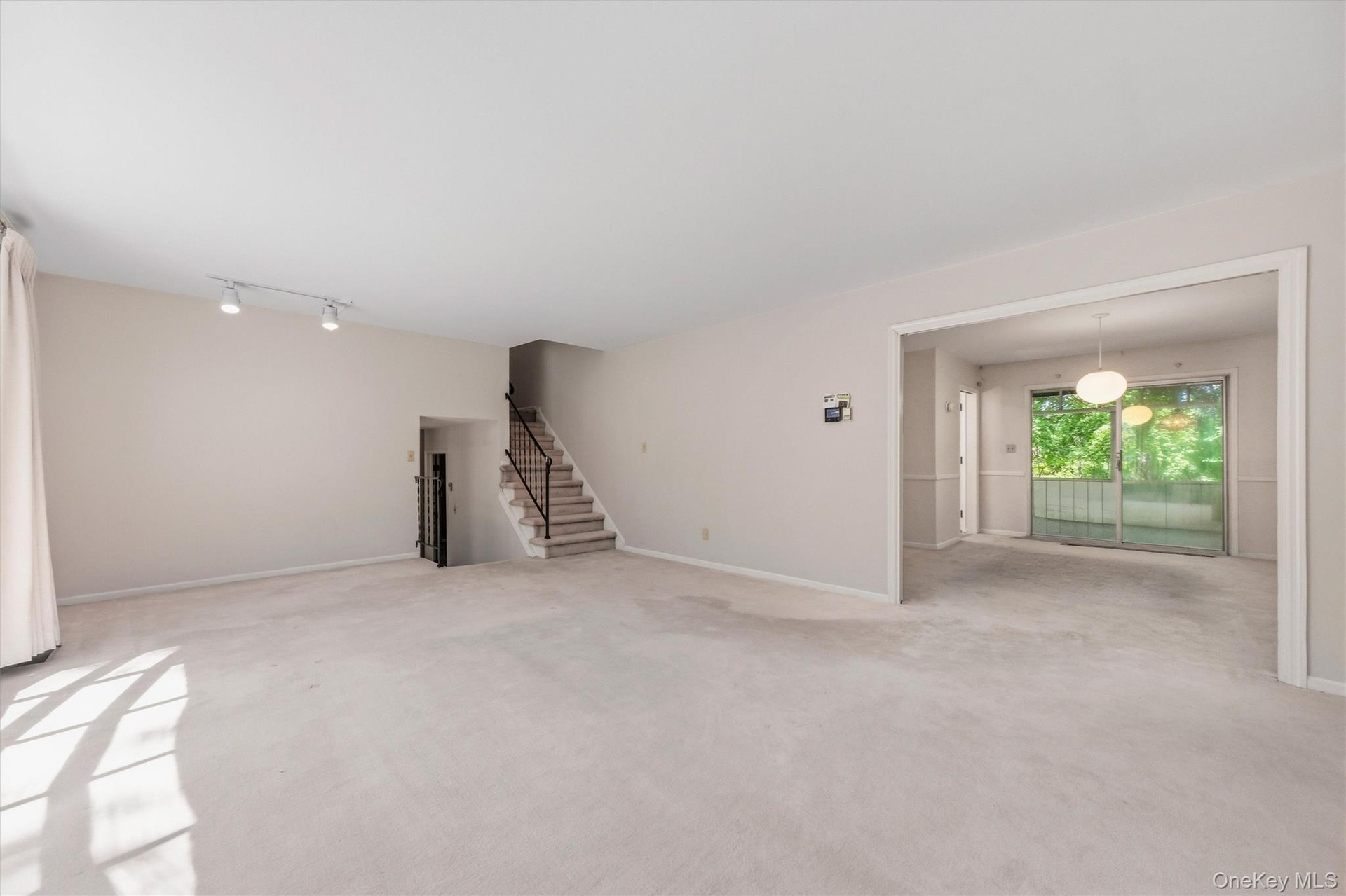 Expansive formal living room with large bow window and wood burning fireplace. Hardwood under carpet.