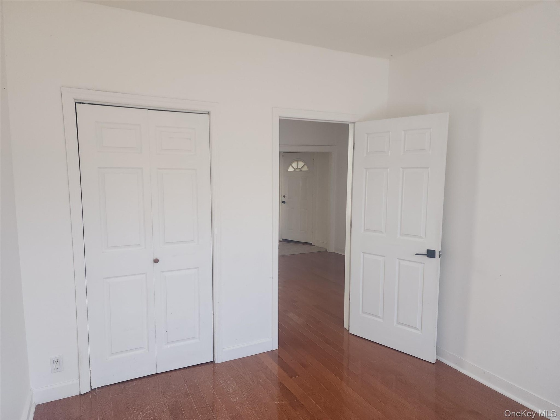 Wood-finish flooring with white trim and white walls