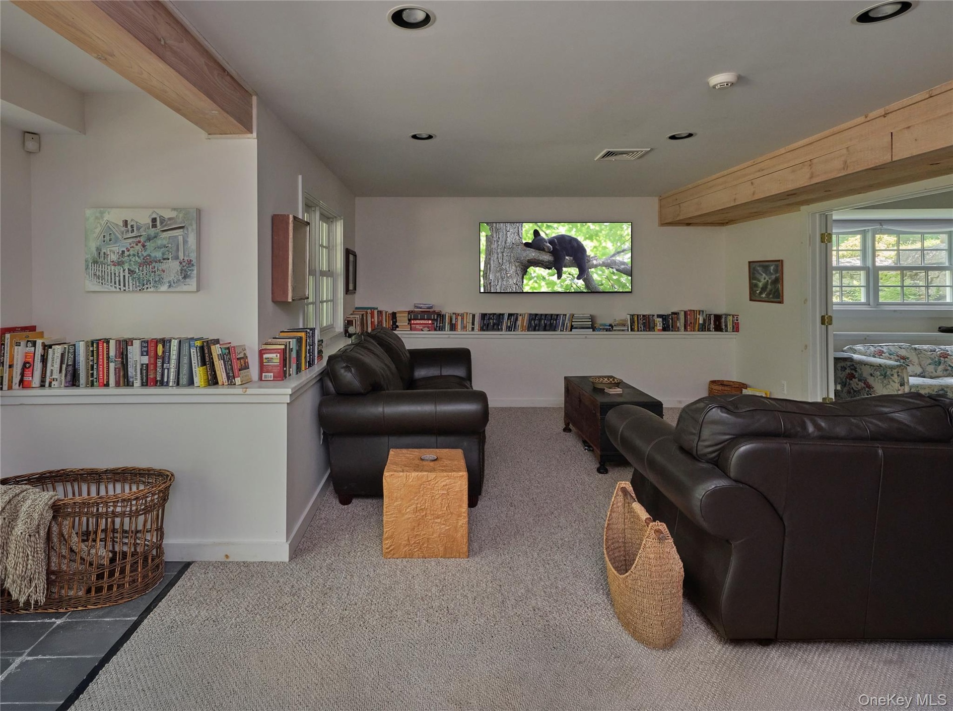 Living area with carpet flooring, beamed ceiling, and recessed lighting