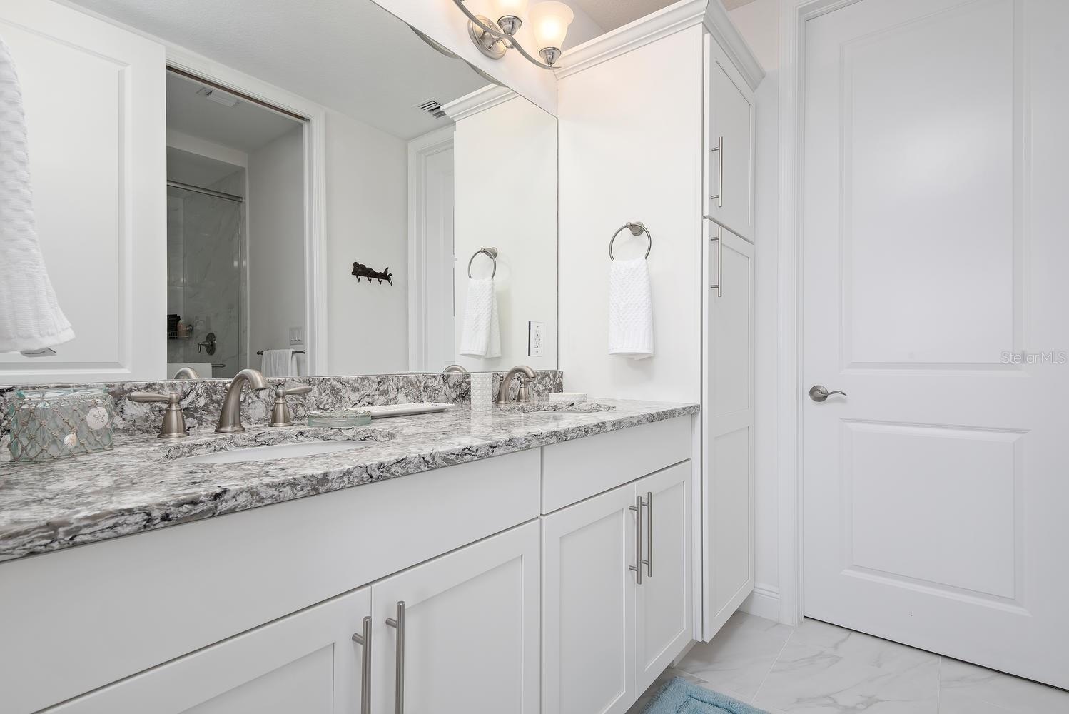 primary bath with double vanities and linen closet