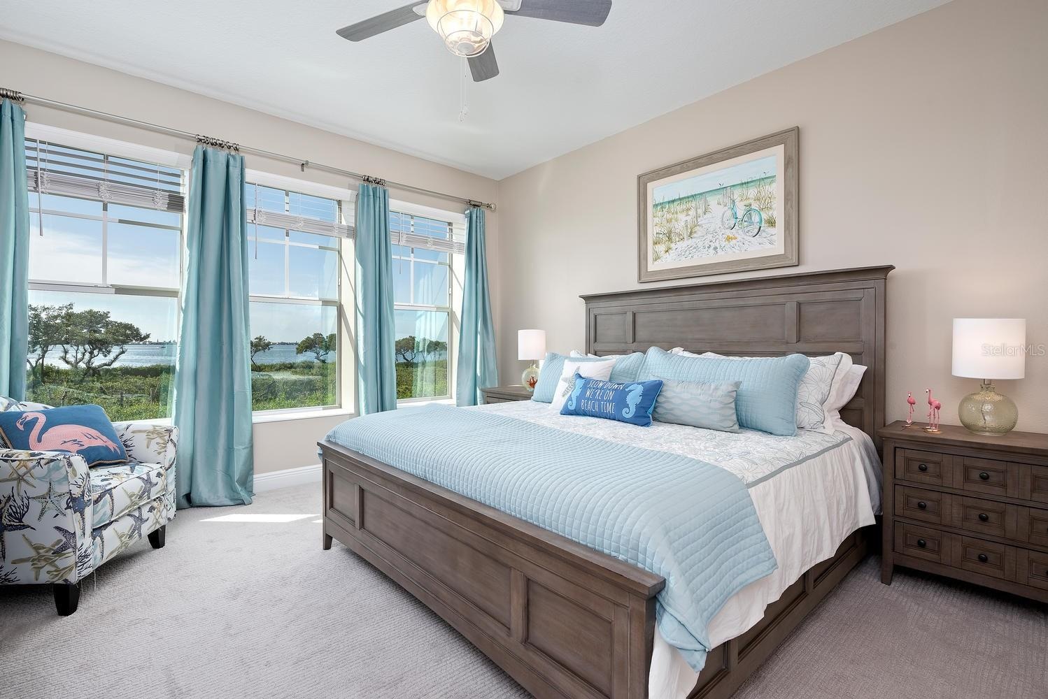 large primary suite with lots of windows and natural light and bay views